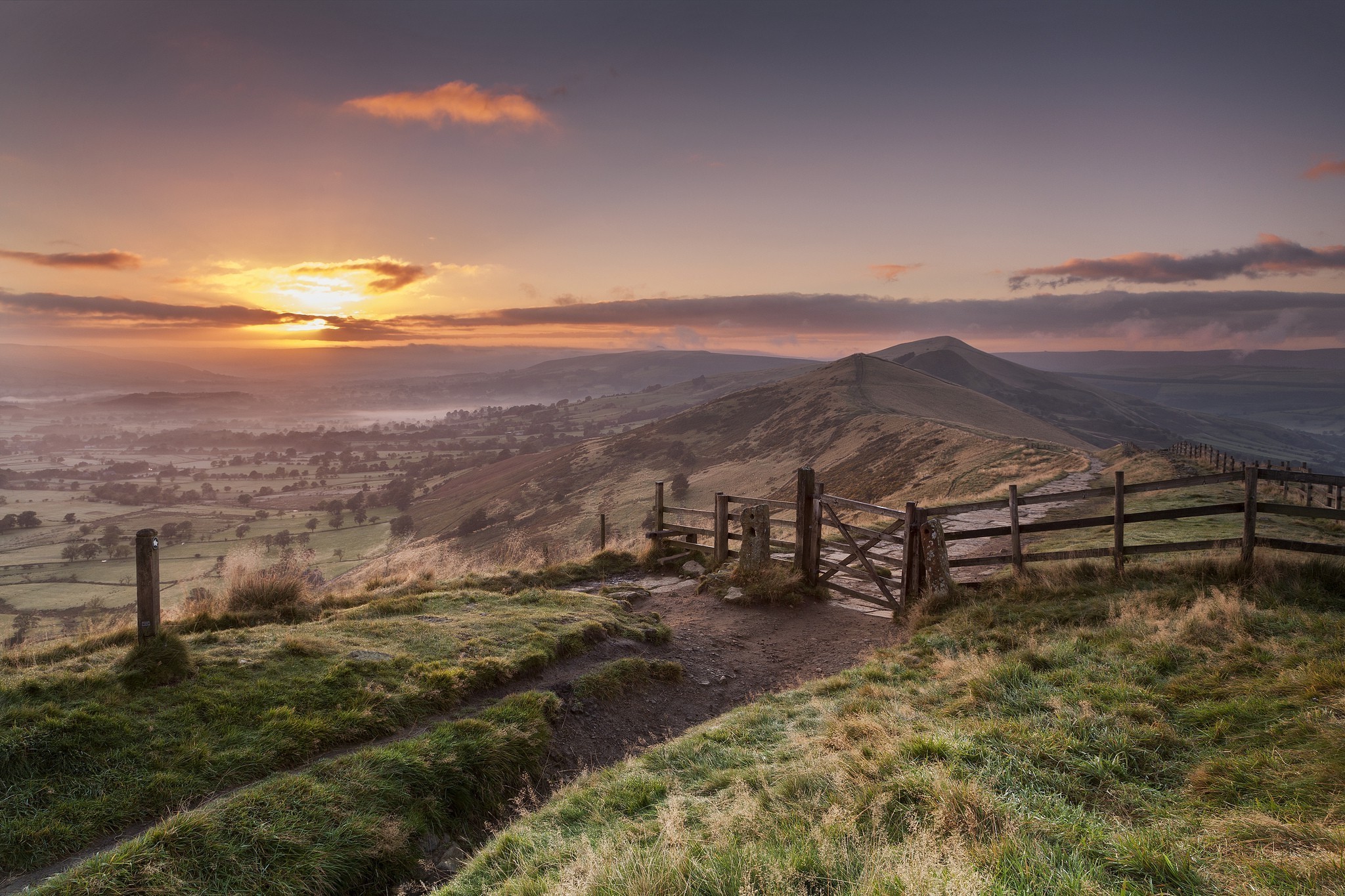 Sunrise over a misty valley with a wooden gate and fence HD Wallpaper