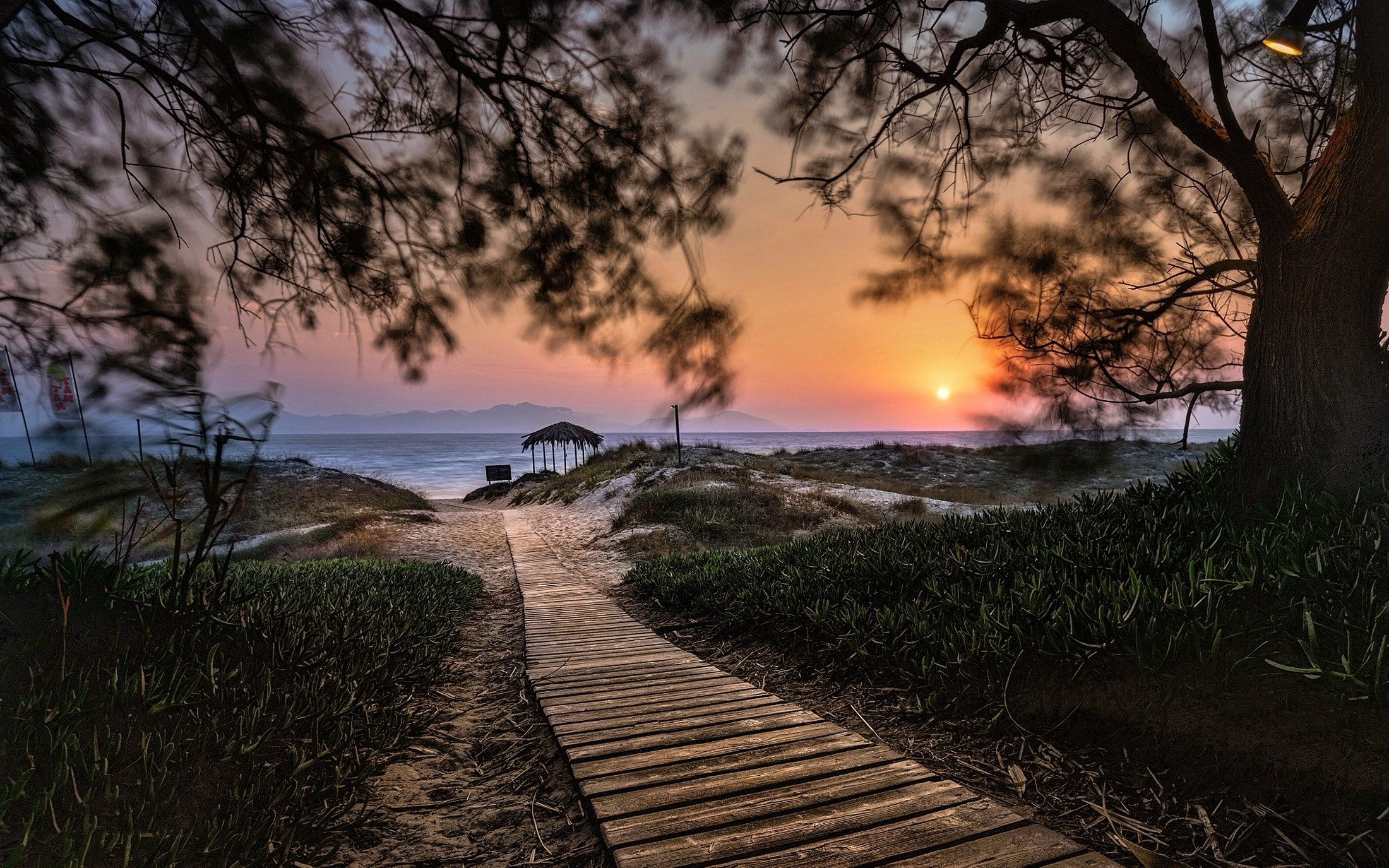 Wooden walkway to a beach hut at sunset HD Wallpaper