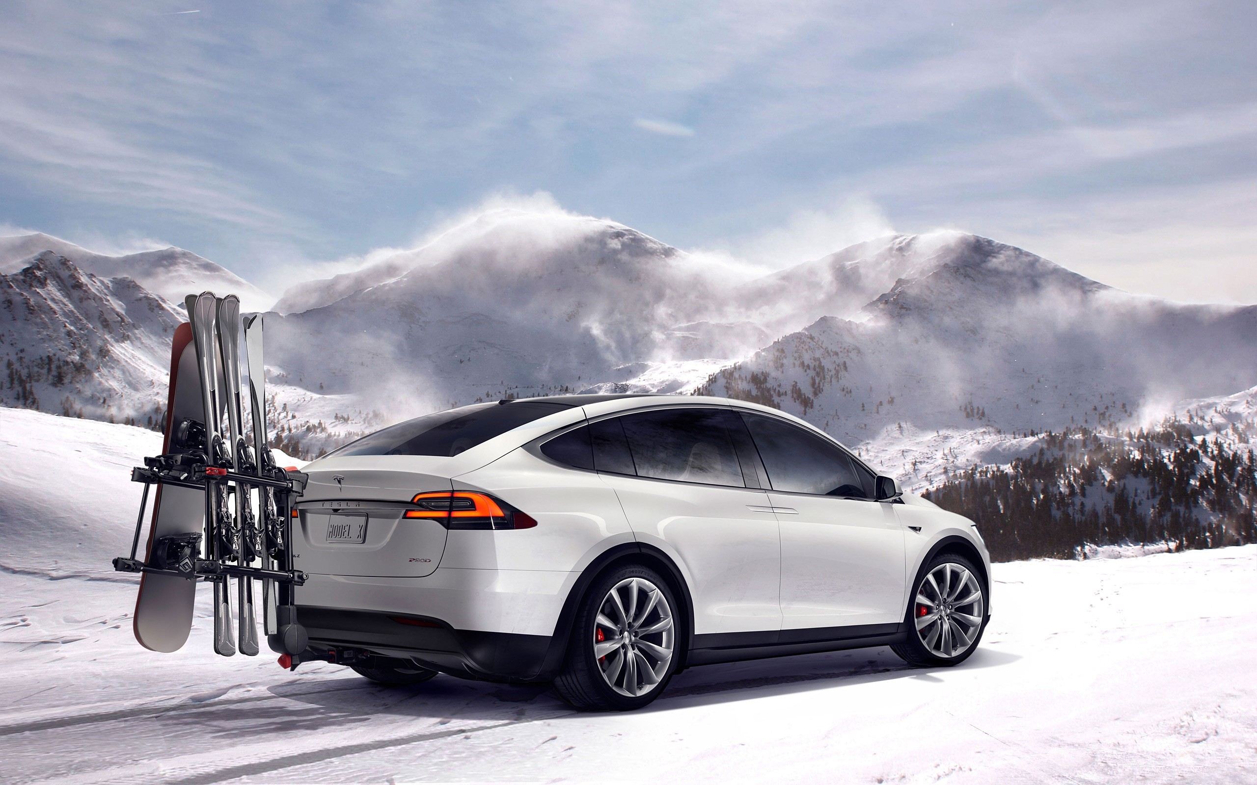 White Tesla Model X with skis and snowboard in snowy mountains HD Wallpaper