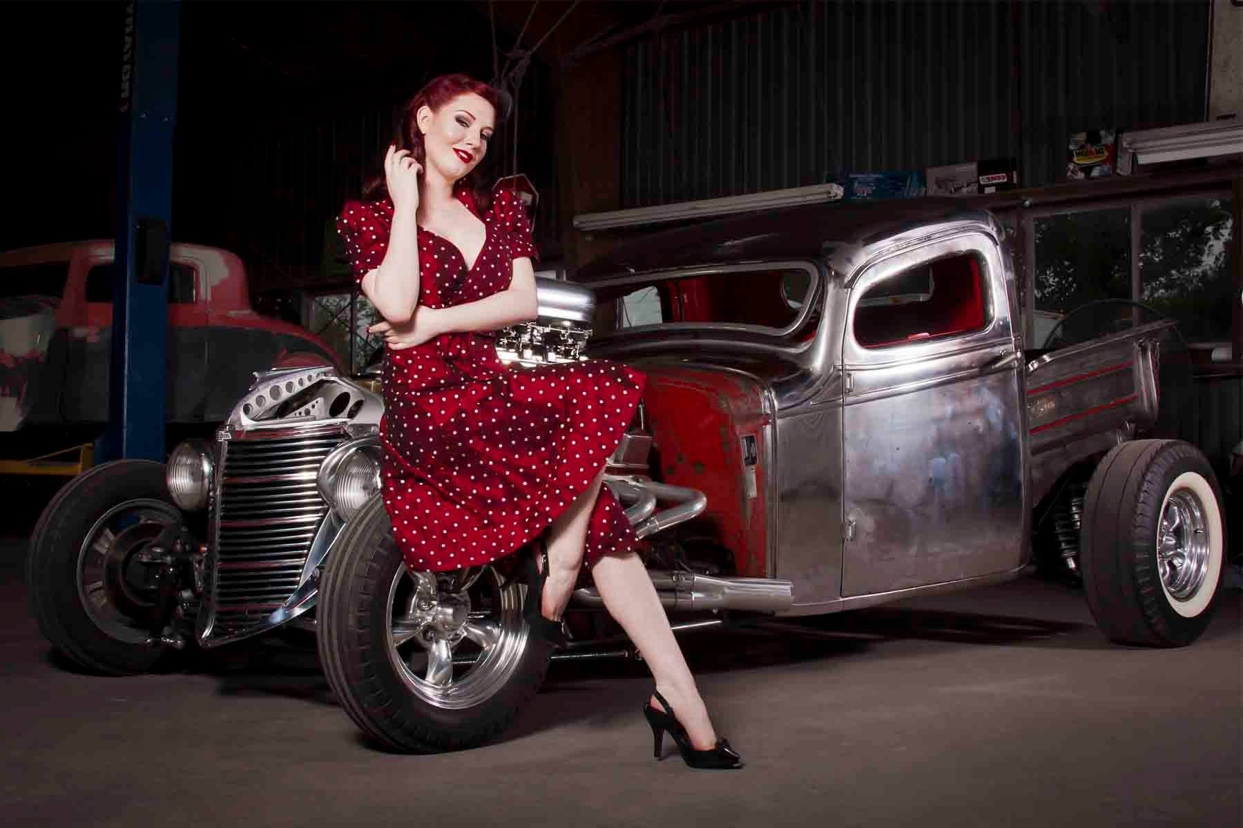 Woman in polka dot dress posing with a hot rod car HD Wallpaper