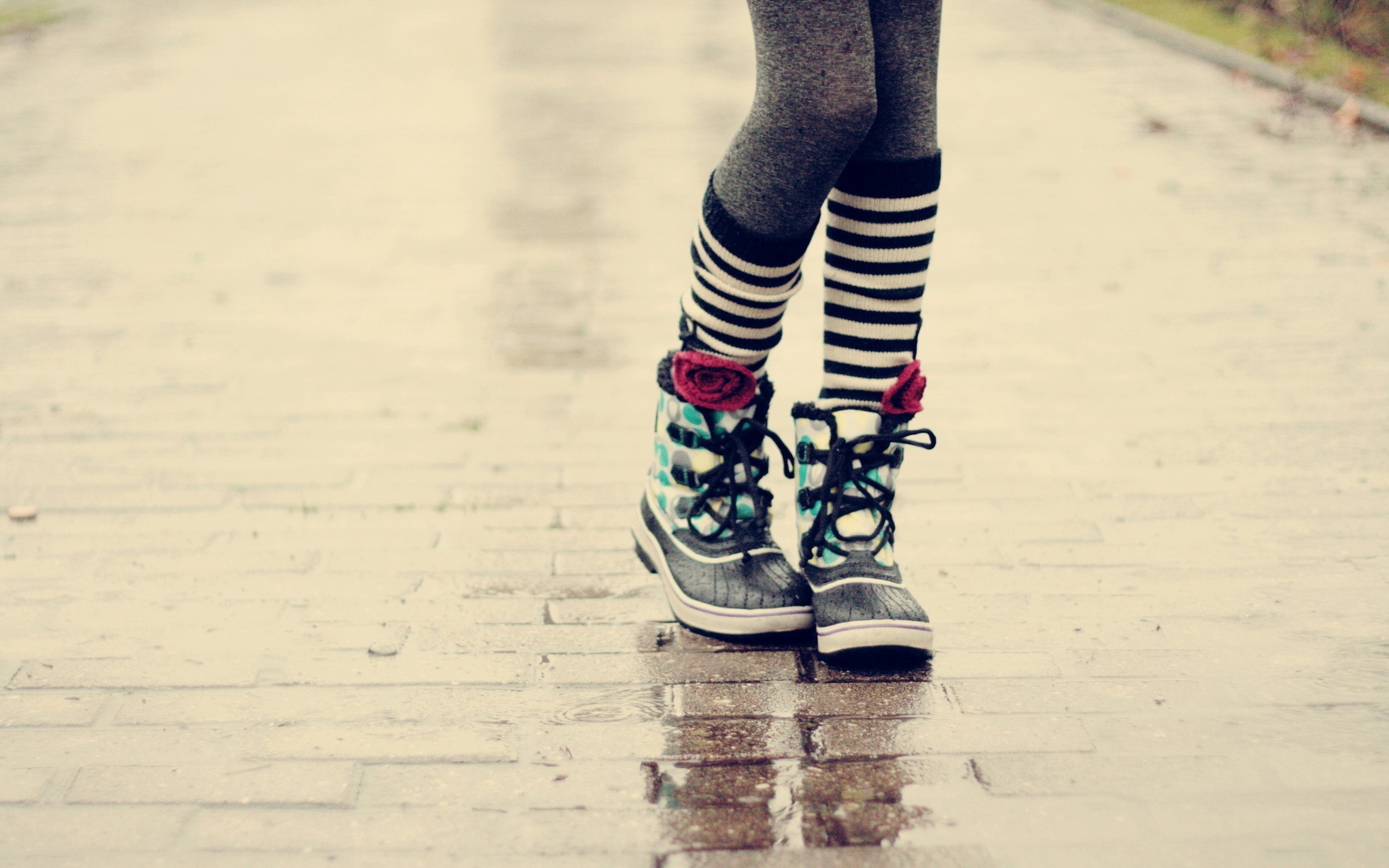 Woman wearing striped socks and boots on wet pavement HD Wallpaper