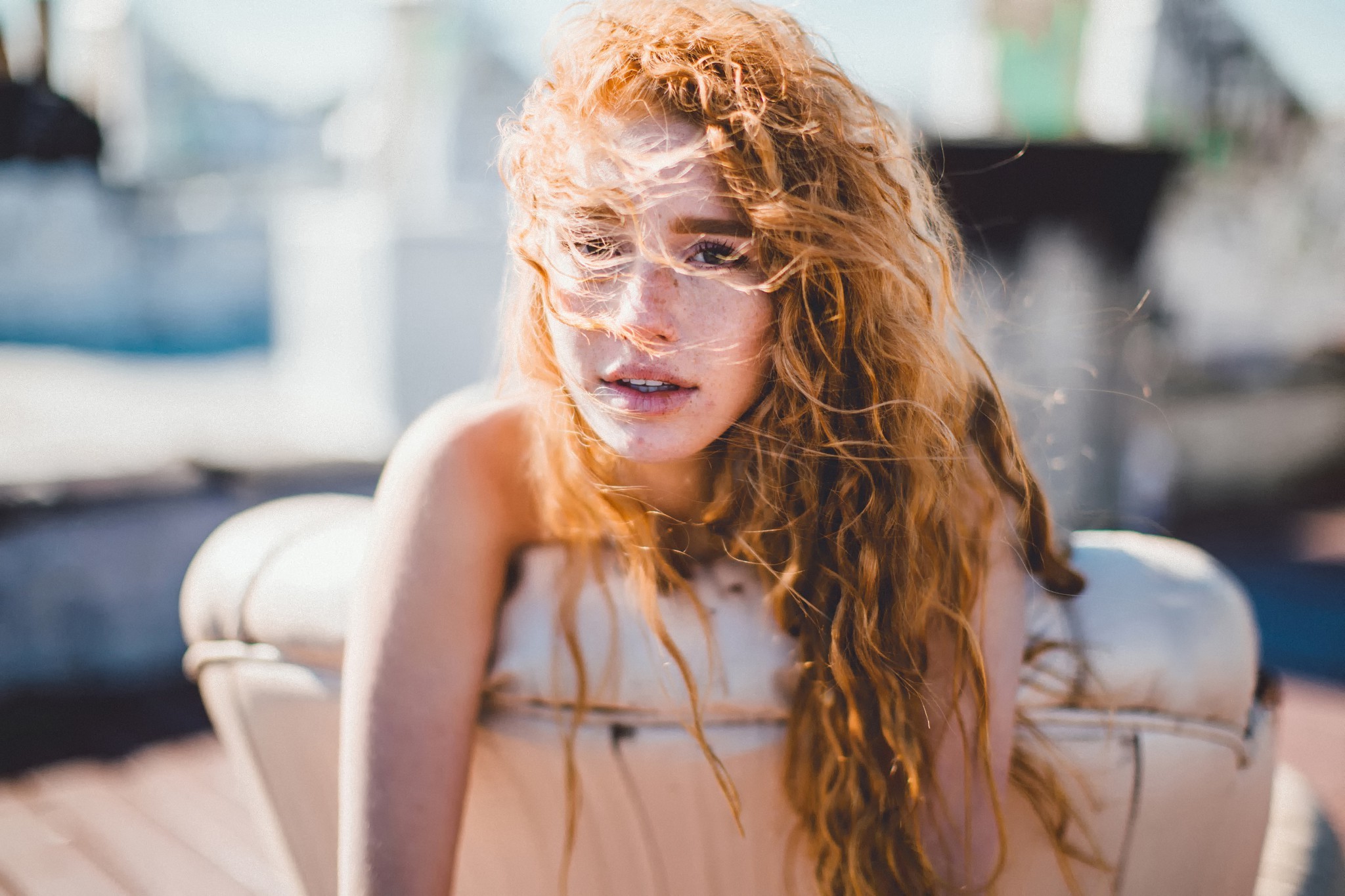 Redhead woman with freckles and wavy hair on a couch HD Wallpaper