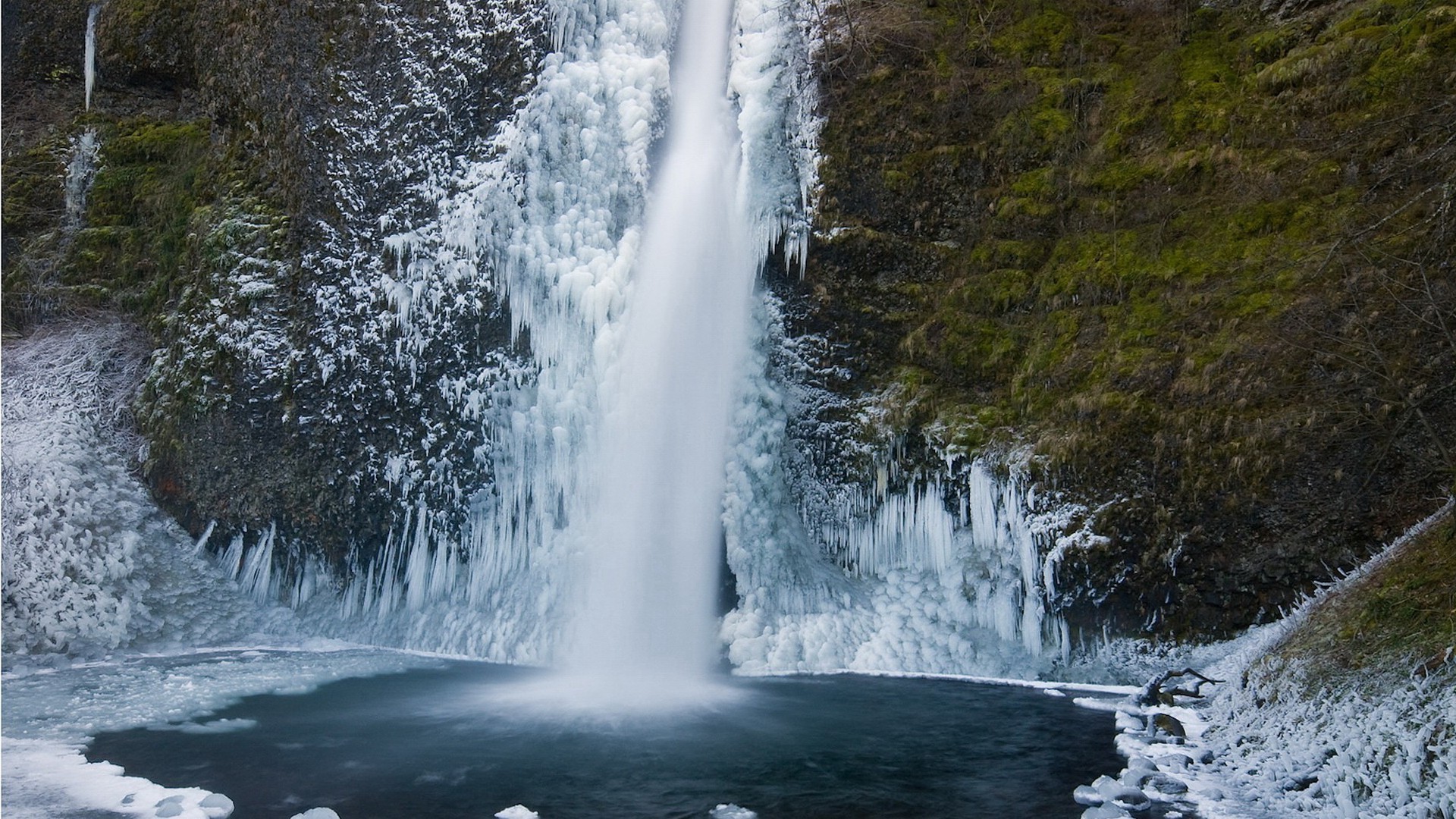 Frozen waterfall with icy formations and a dark pool HD Wallpaper