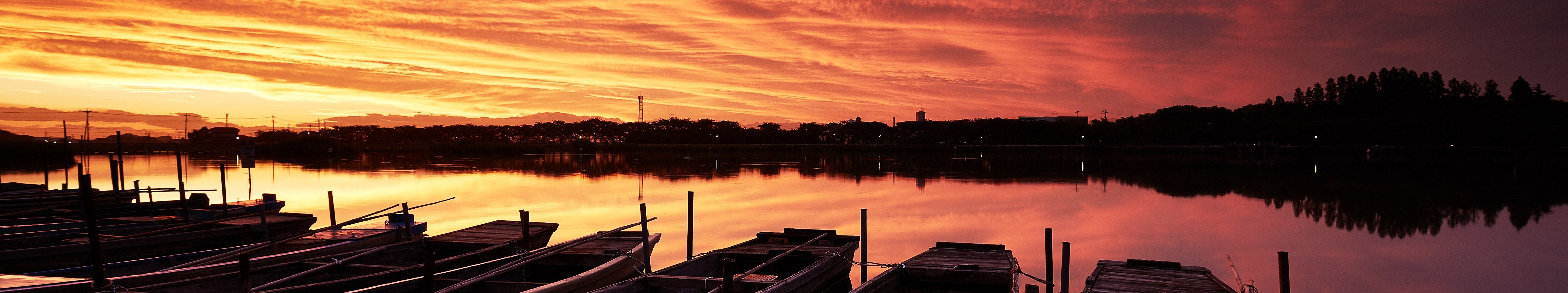 Panoramic sunset over a lake with boats HD Wallpaper