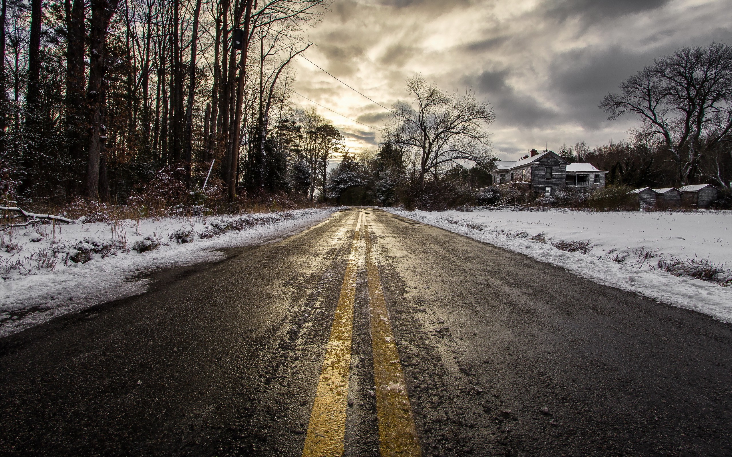 Snowy road leading to an abandoned house in winter HD Wallpaper
