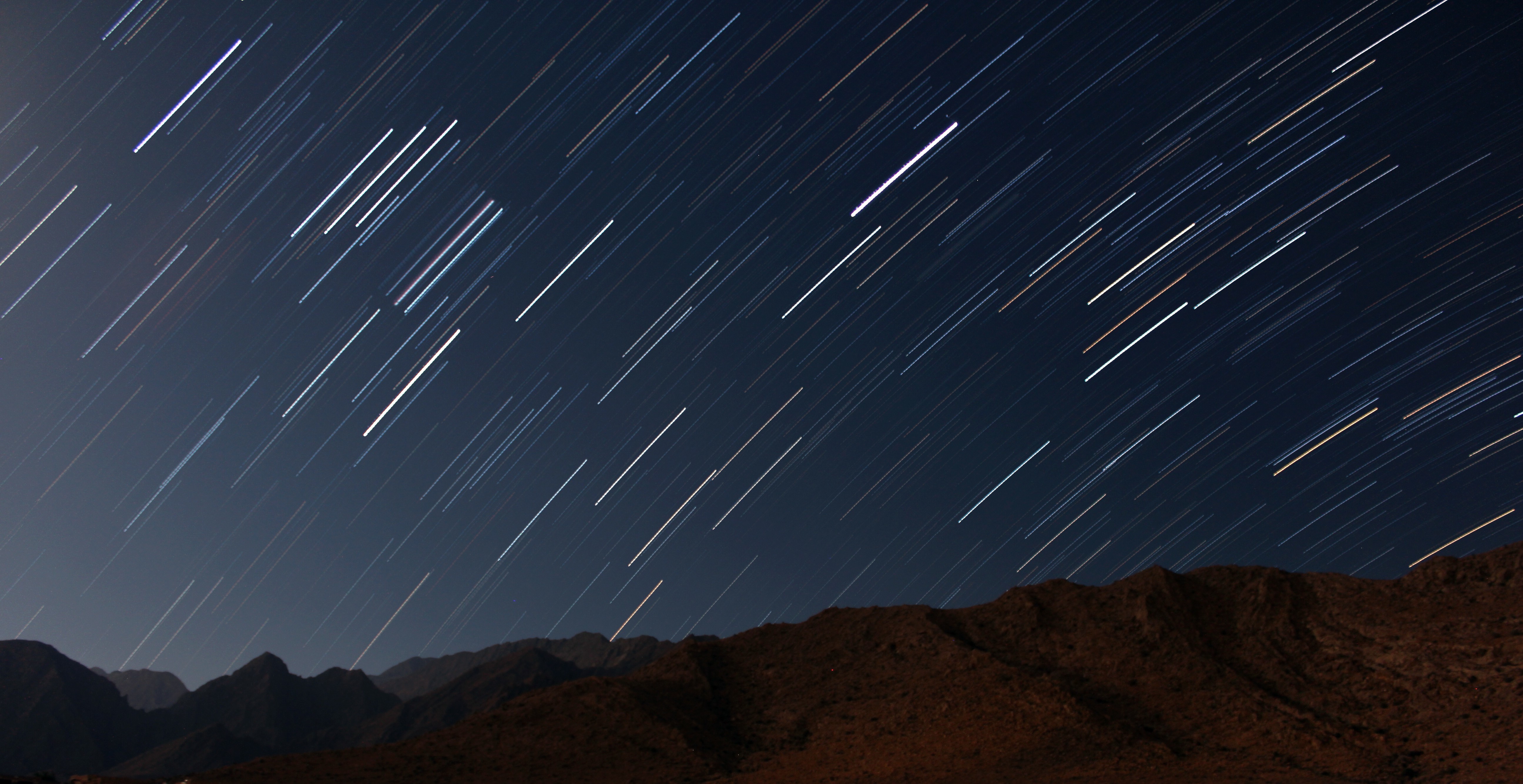 Star trails over mountains at night HD Wallpaper