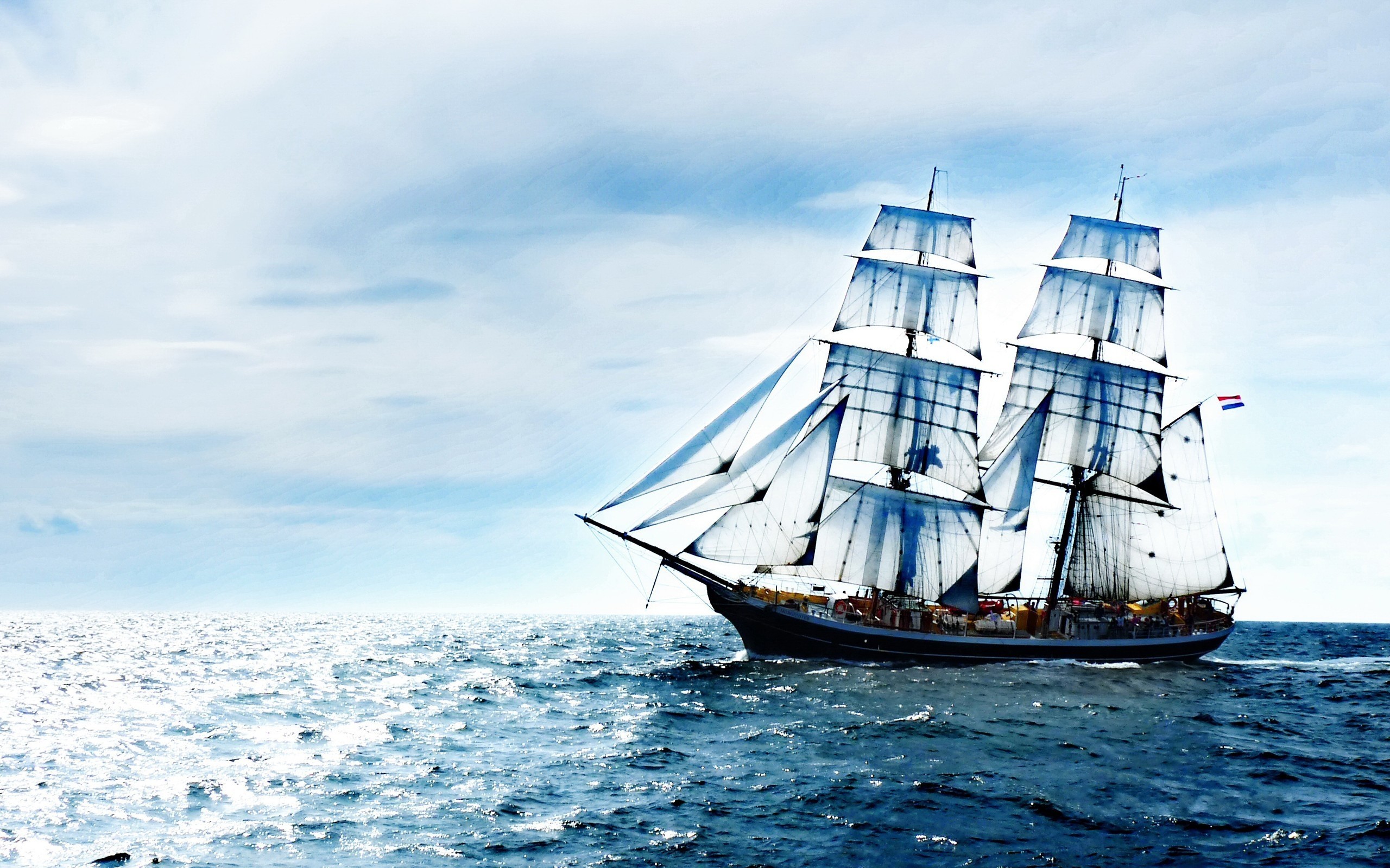 Tall ship sailing on the ocean under a cloudy sky HD Wallpaper