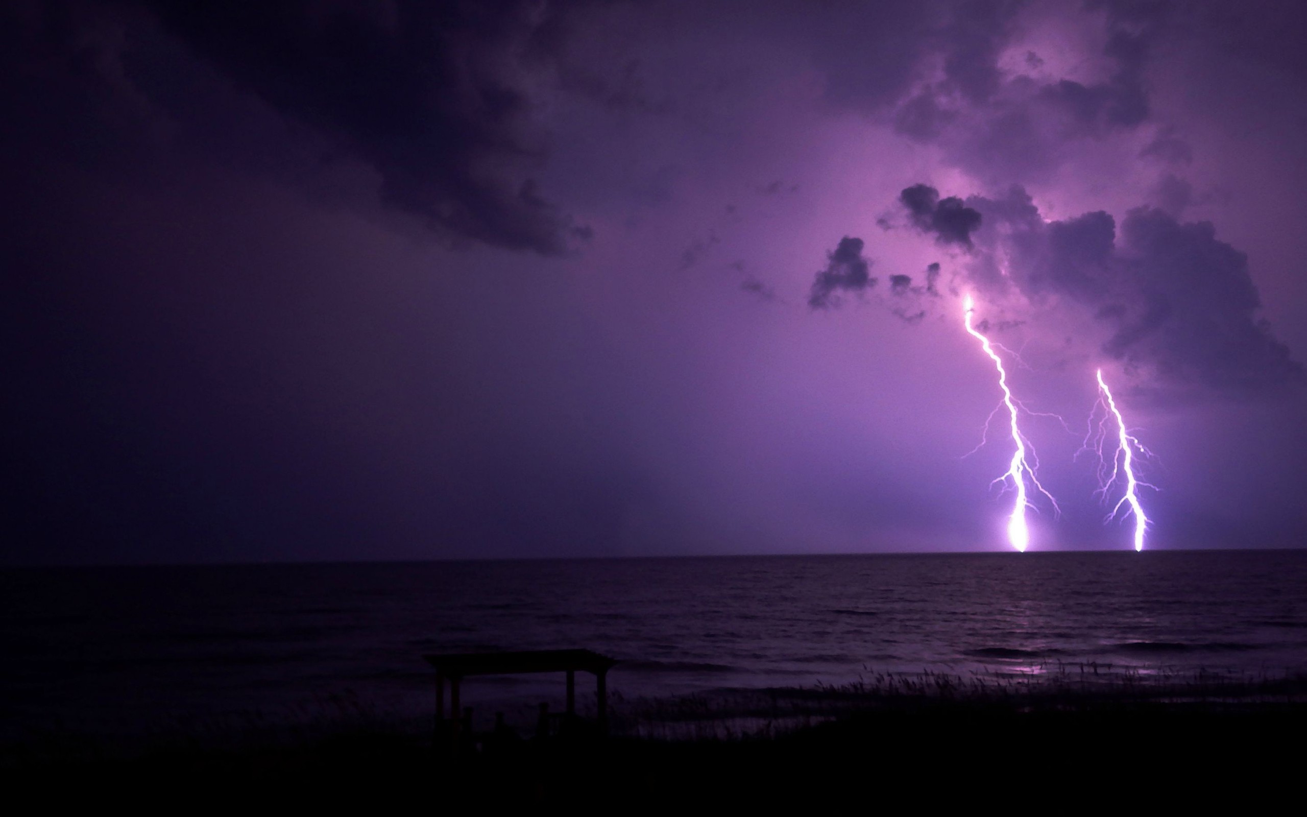 Lightning strikes over the ocean at night HD Wallpaper