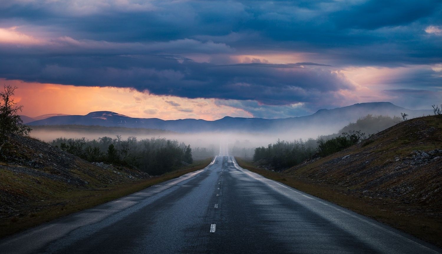 Road through misty mountains at sunset HD Wallpaper