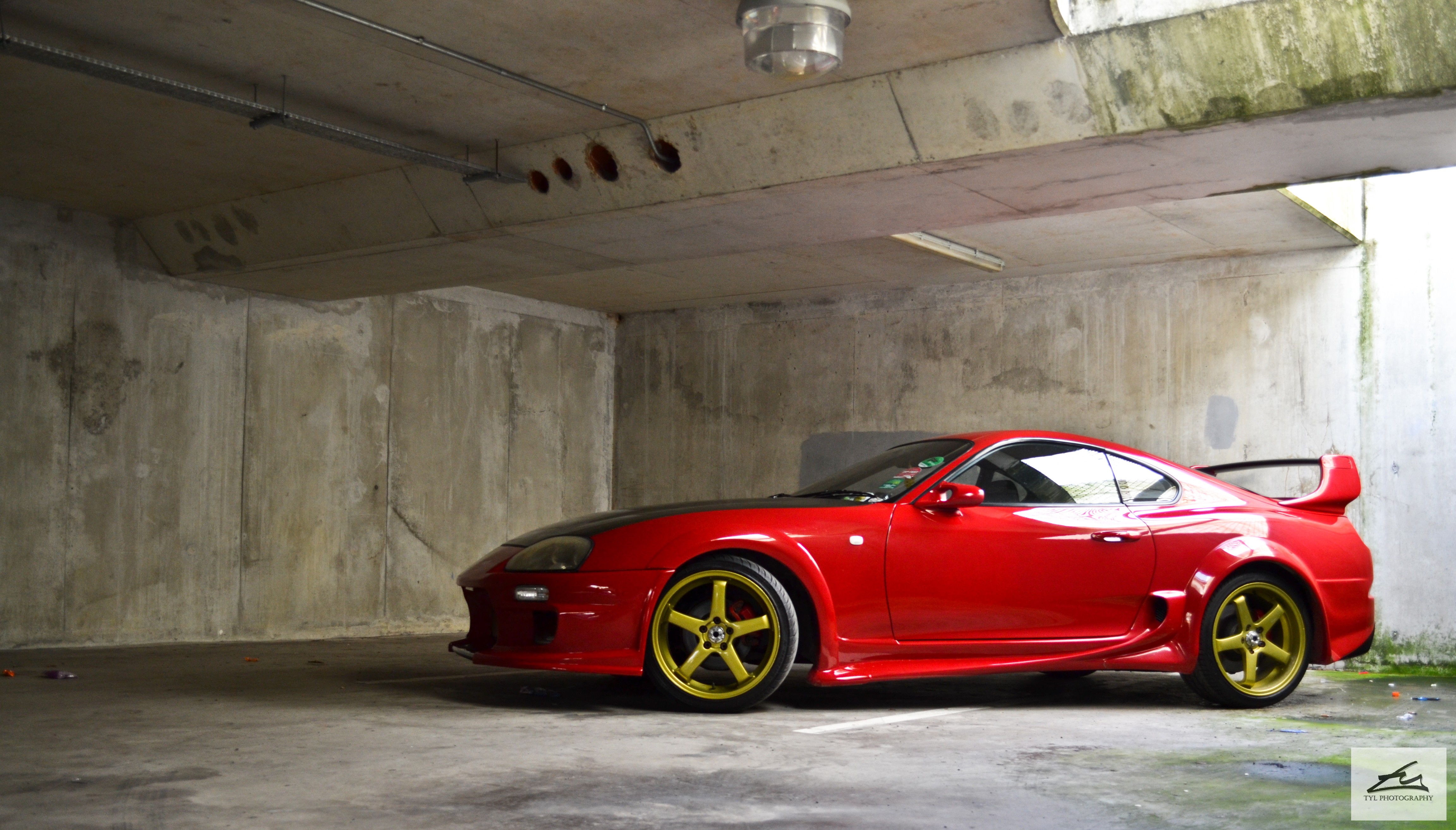 Red Toyota Supra with gold rims in parking garage HD Wallpaper