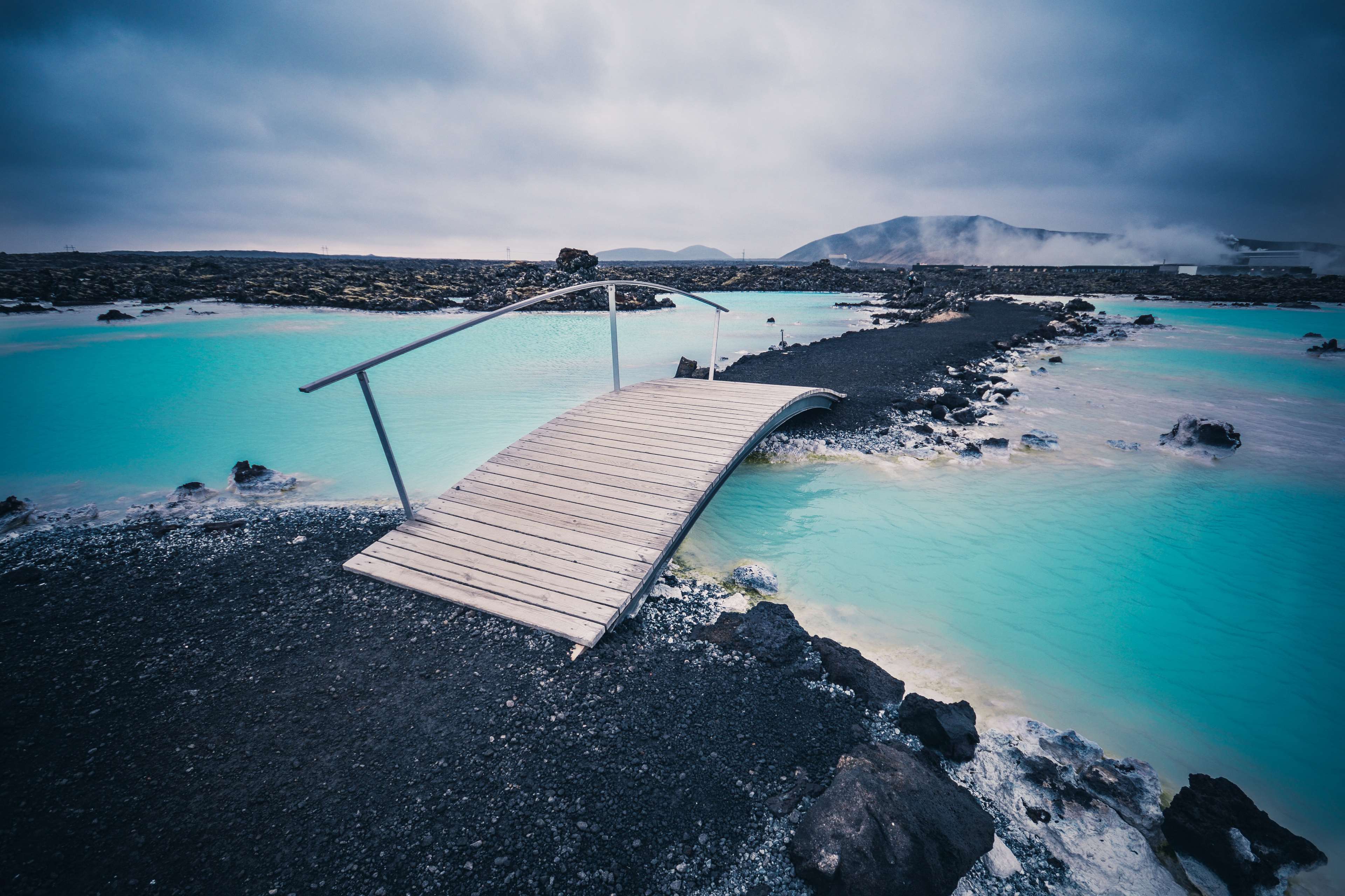 Wooden bridge over blue water in Iceland HD Wallpaper