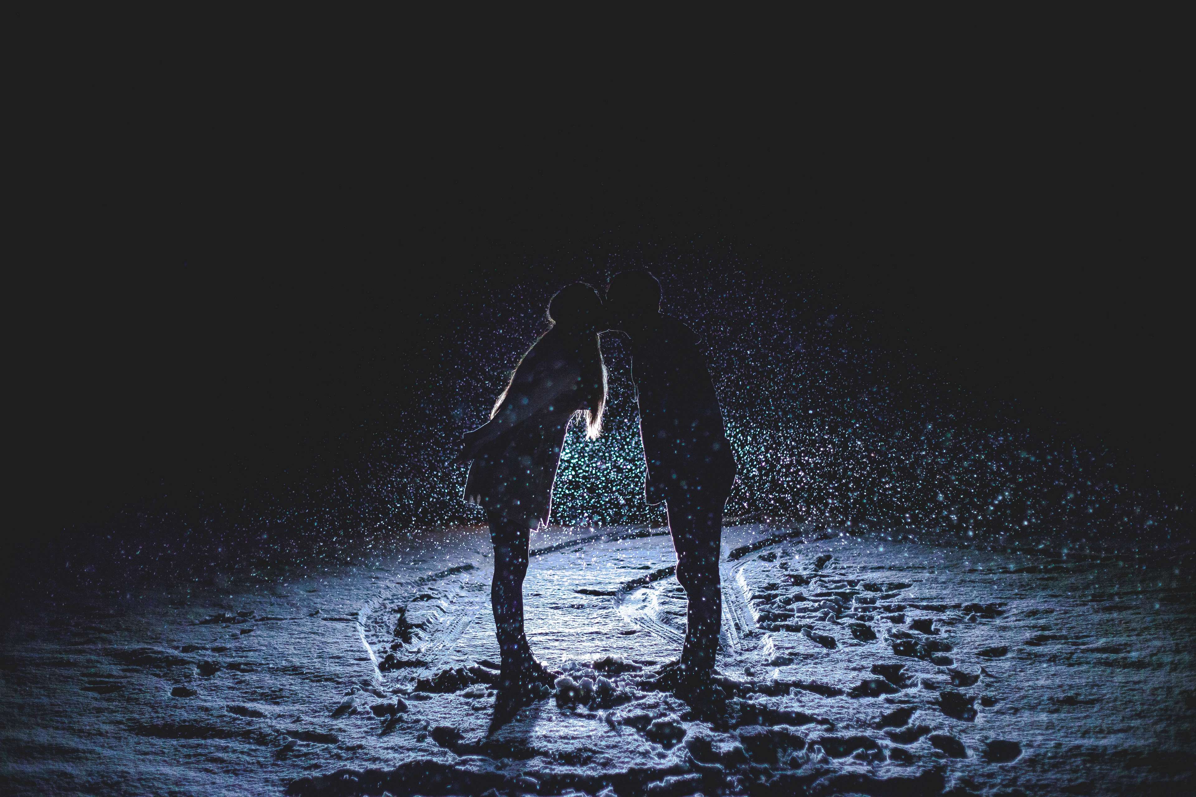 Couple kissing in the snow at night HD Wallpaper