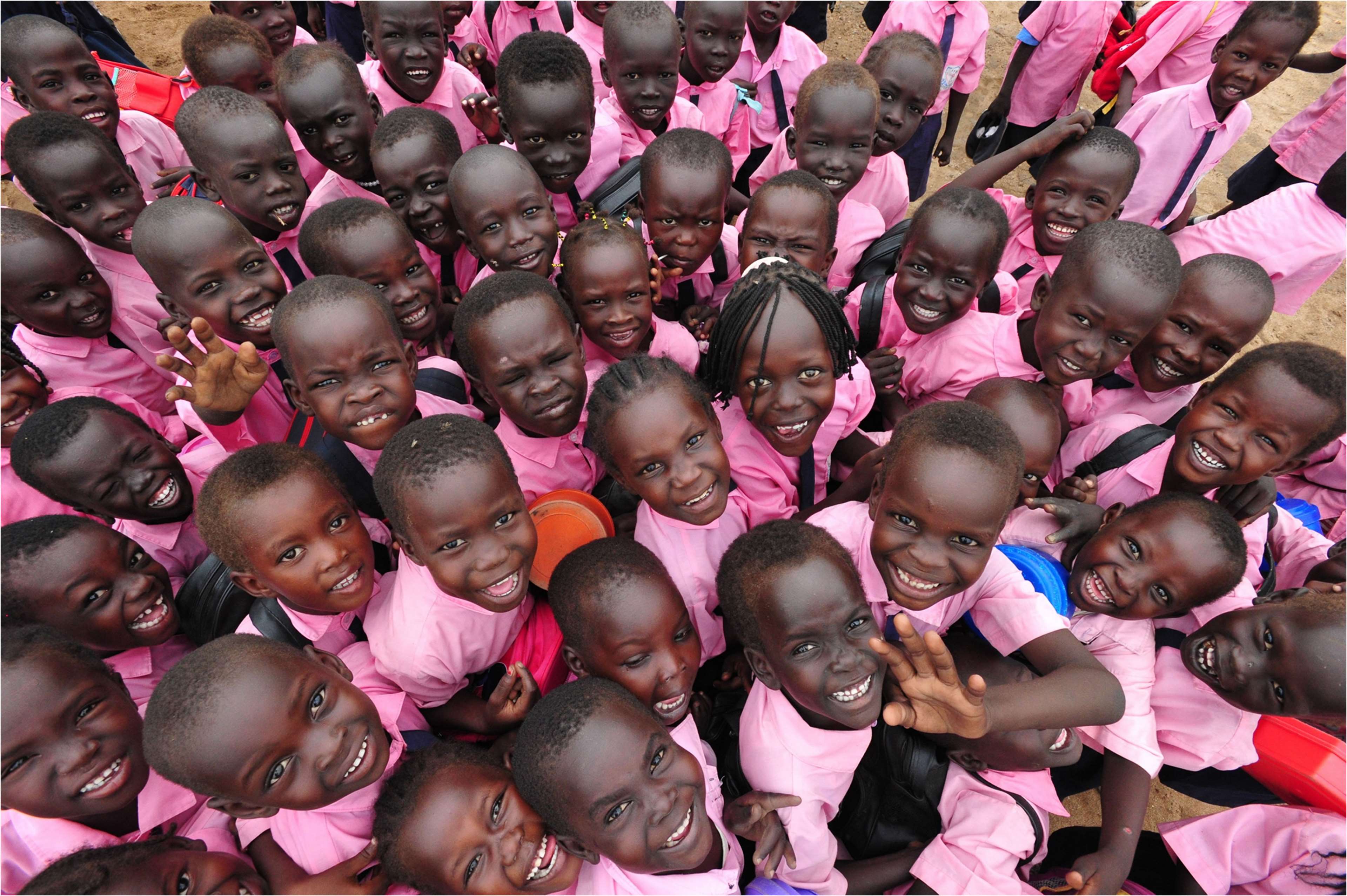 Group of smiling children in pink uniforms HD Wallpaper