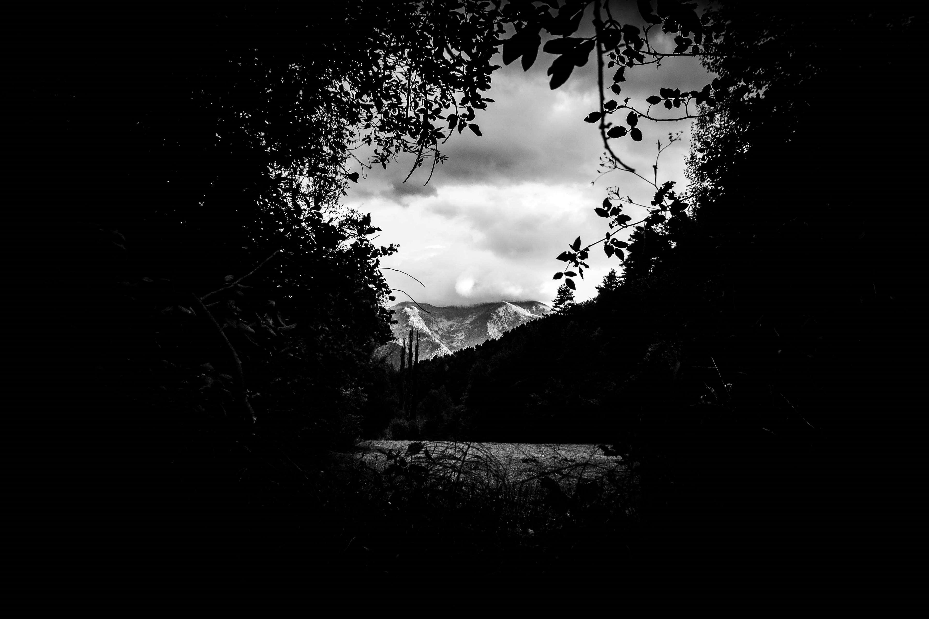 Framed view of mountains over a lake HD Wallpaper