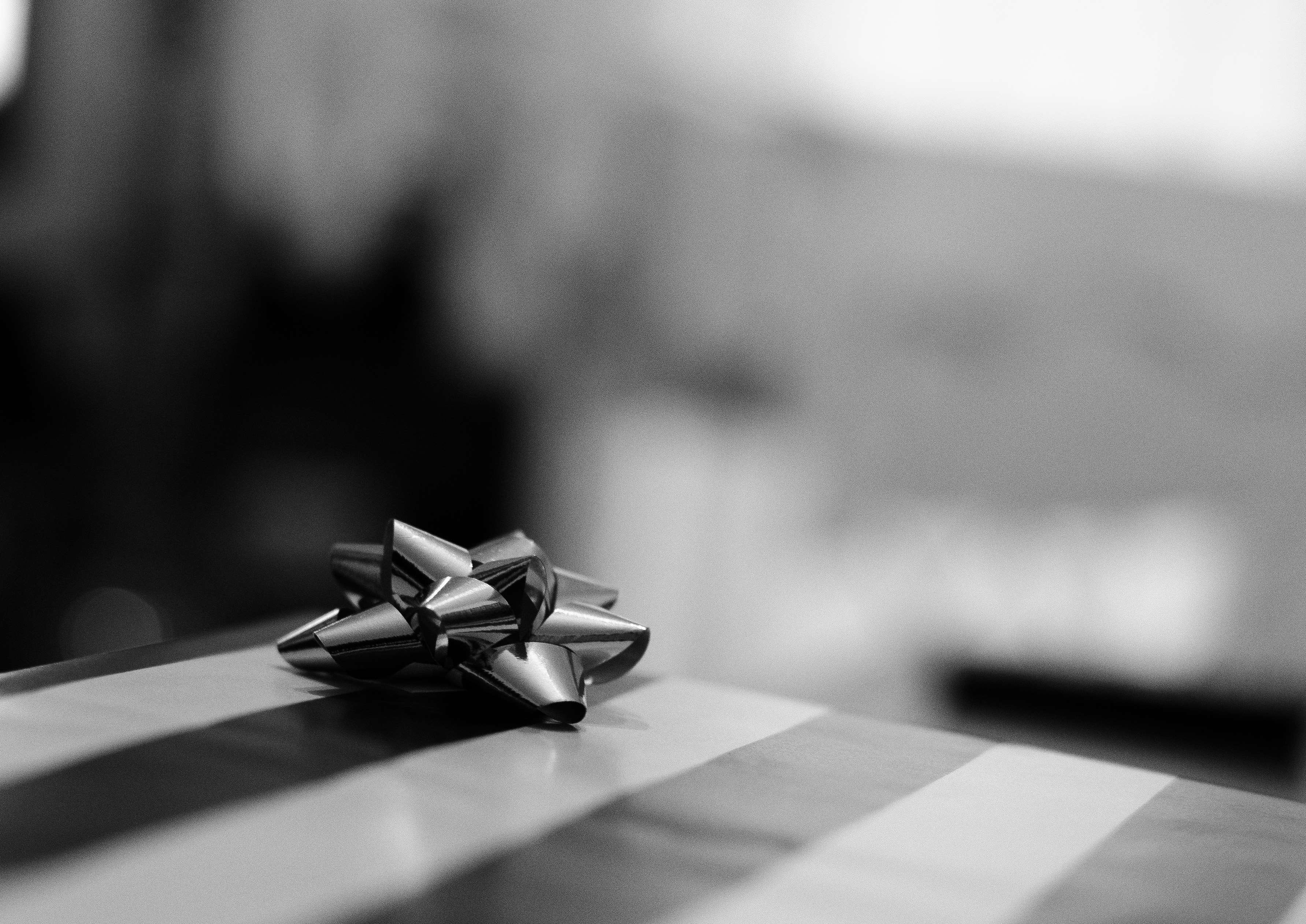 Gift wrap with a silver bow on a table HD Wallpaper