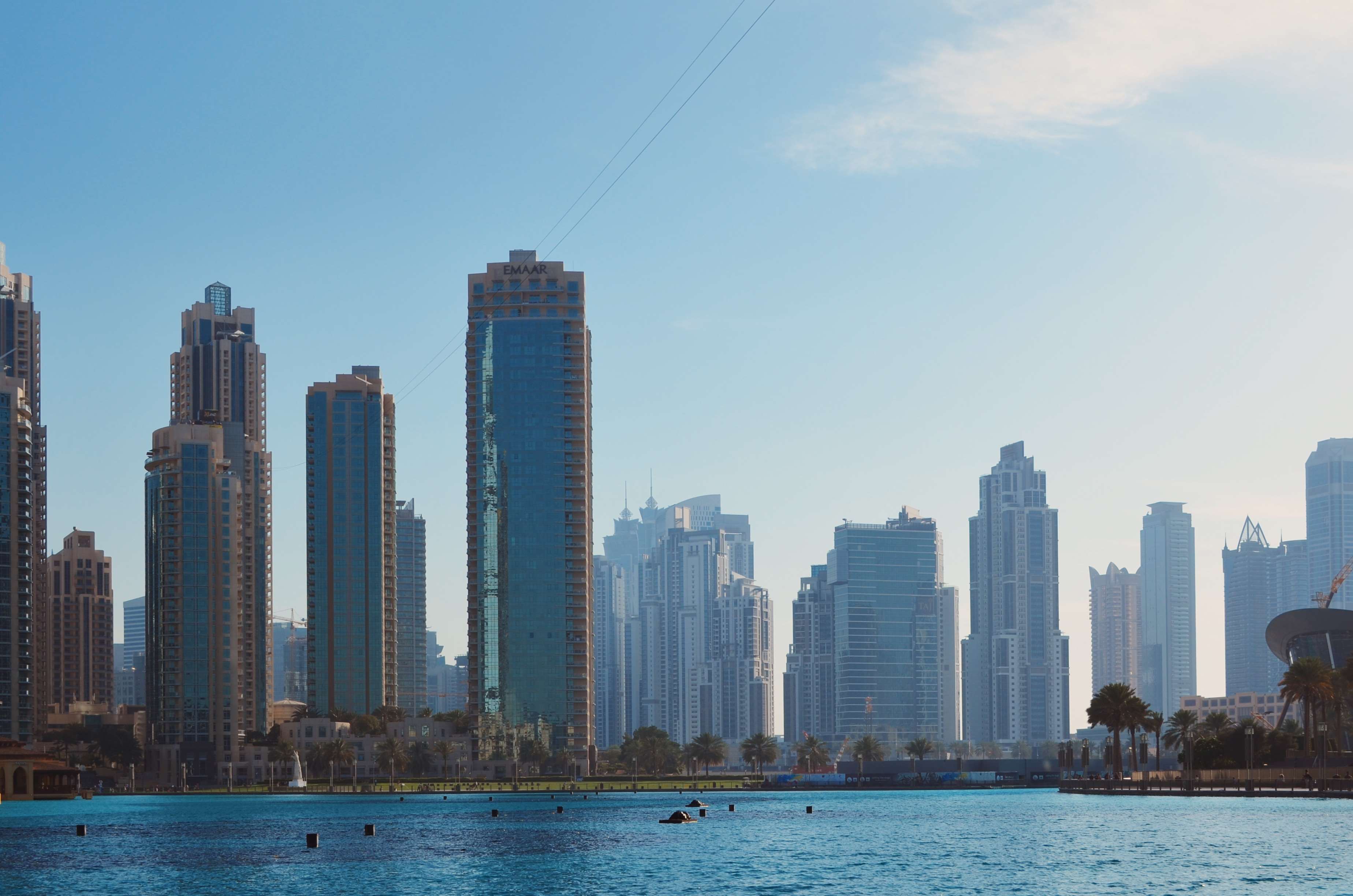 Dubai skyline with skyscrapers and a body of water HD Wallpaper