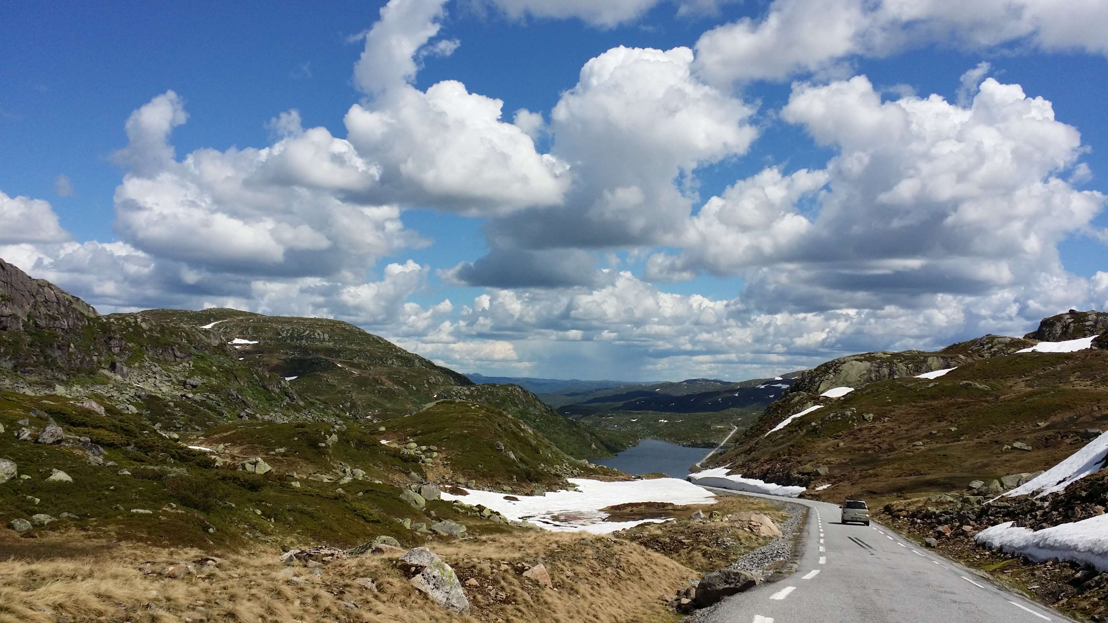 Road through mountains in Norway with lake and clouds HD Wallpaper
