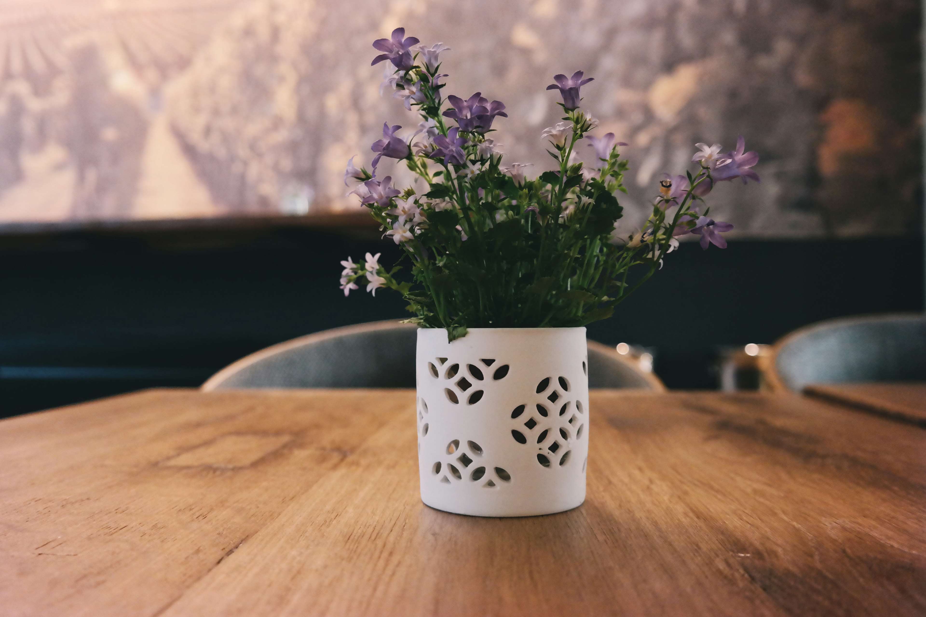 Purple flowers in a white vase on a wooden table HD Wallpaper