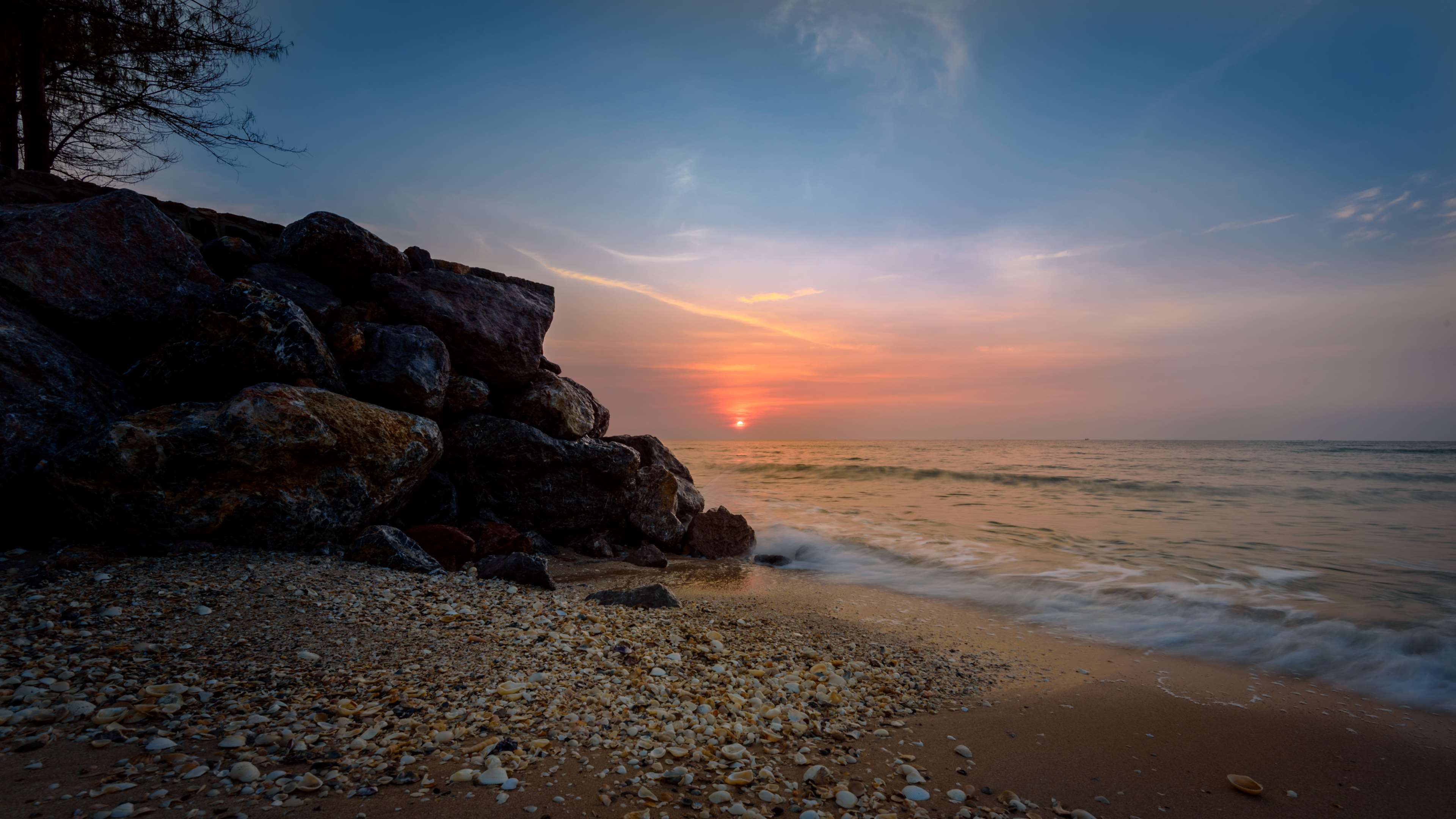 Beach with rocks and ocean at sunset HD Wallpaper