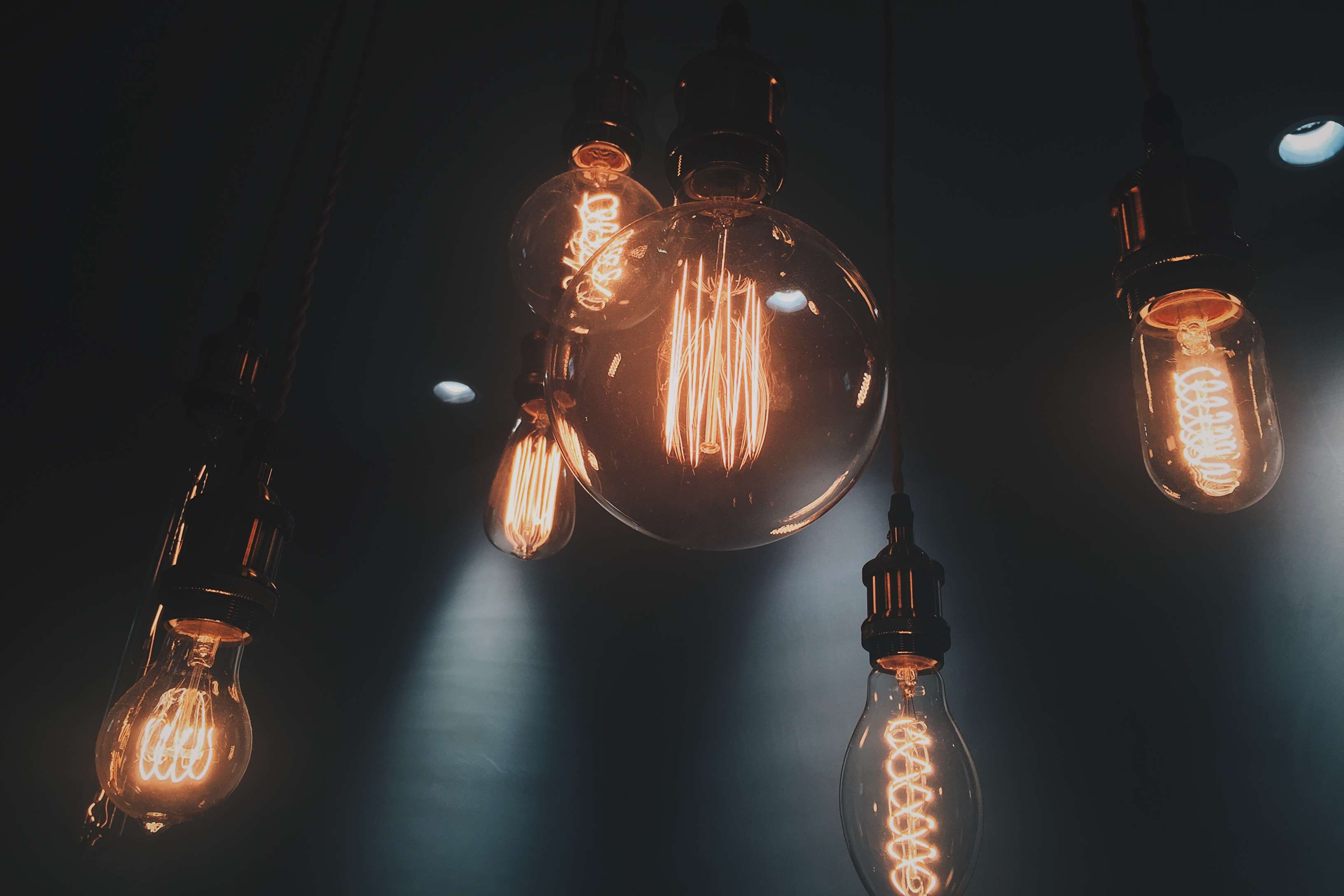 Several incandescent light bulbs hanging in the dark HD Wallpaper