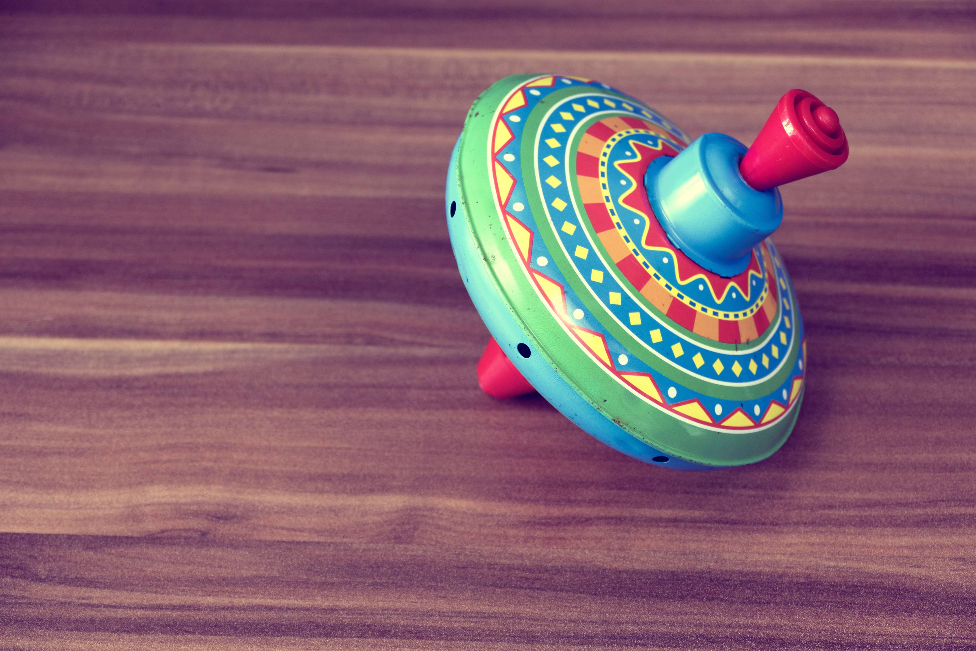Colorful vintage spinning top on a wooden table HD Wallpaper