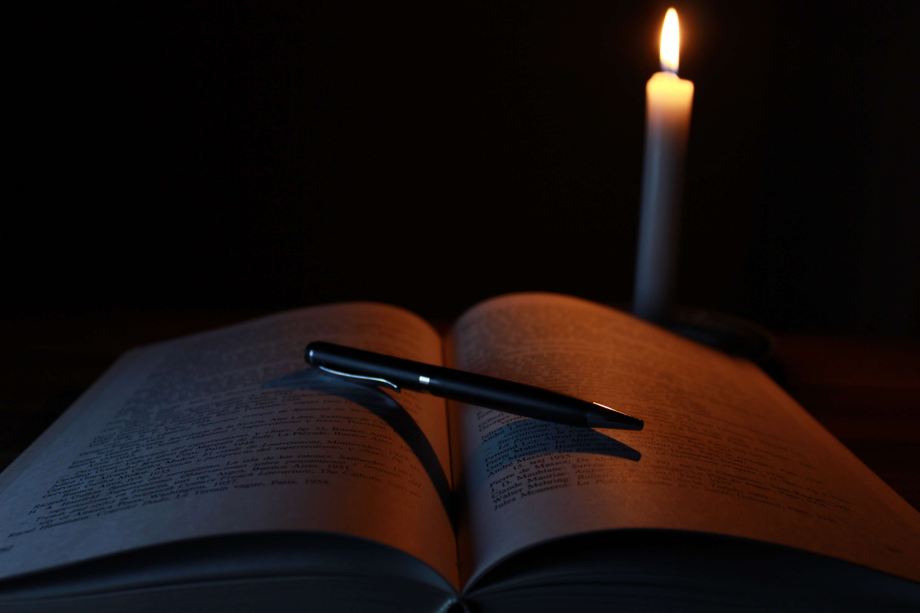 Open book and pen by candlelight 4K HD Wallpaper
