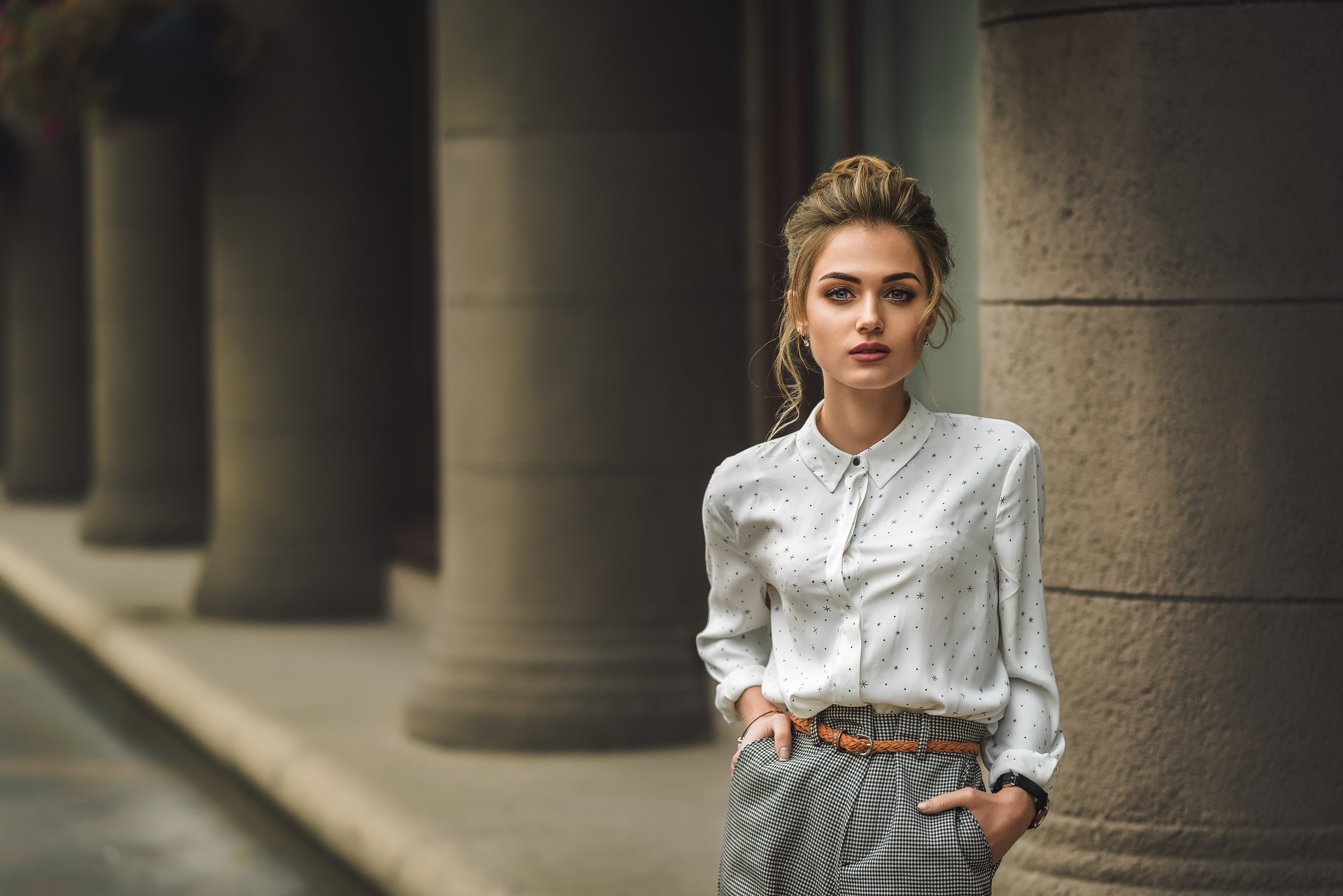 Woman in patterned shirt and pants standing by columns HD Wallpaper