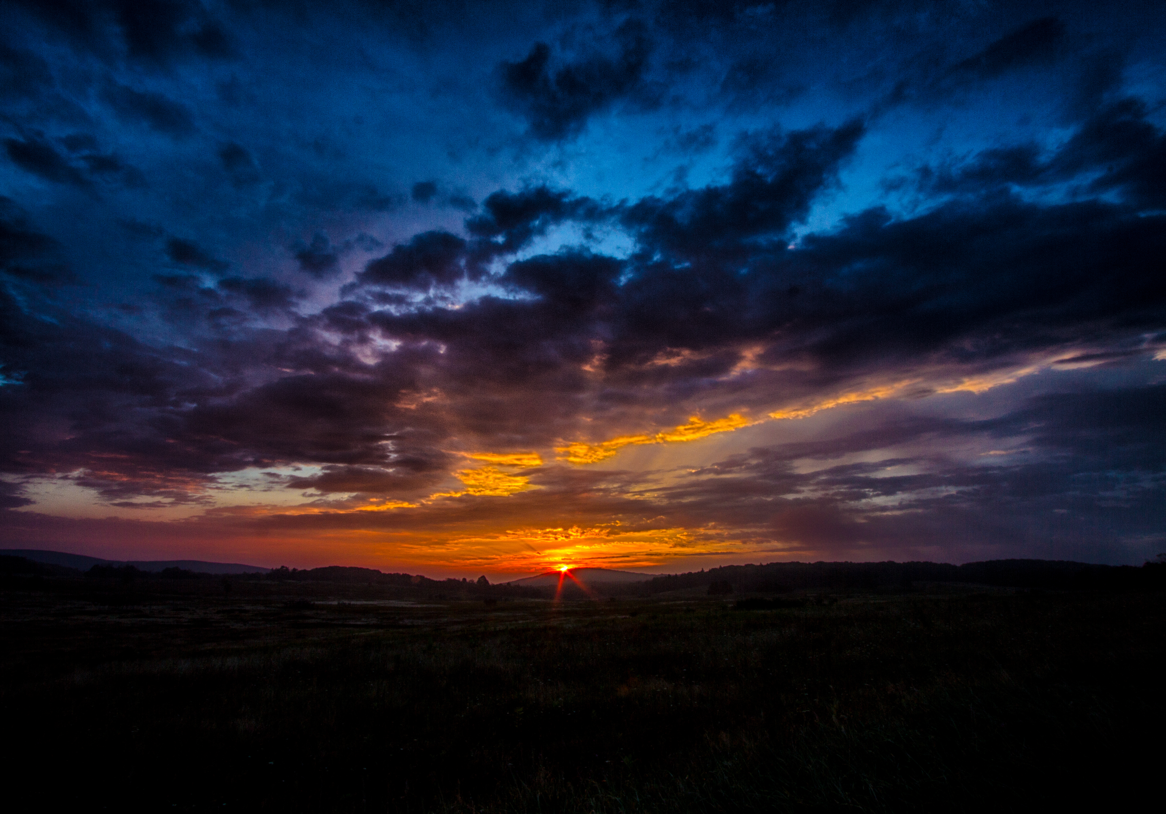 Sunset over a dark landscape HD Wallpaper