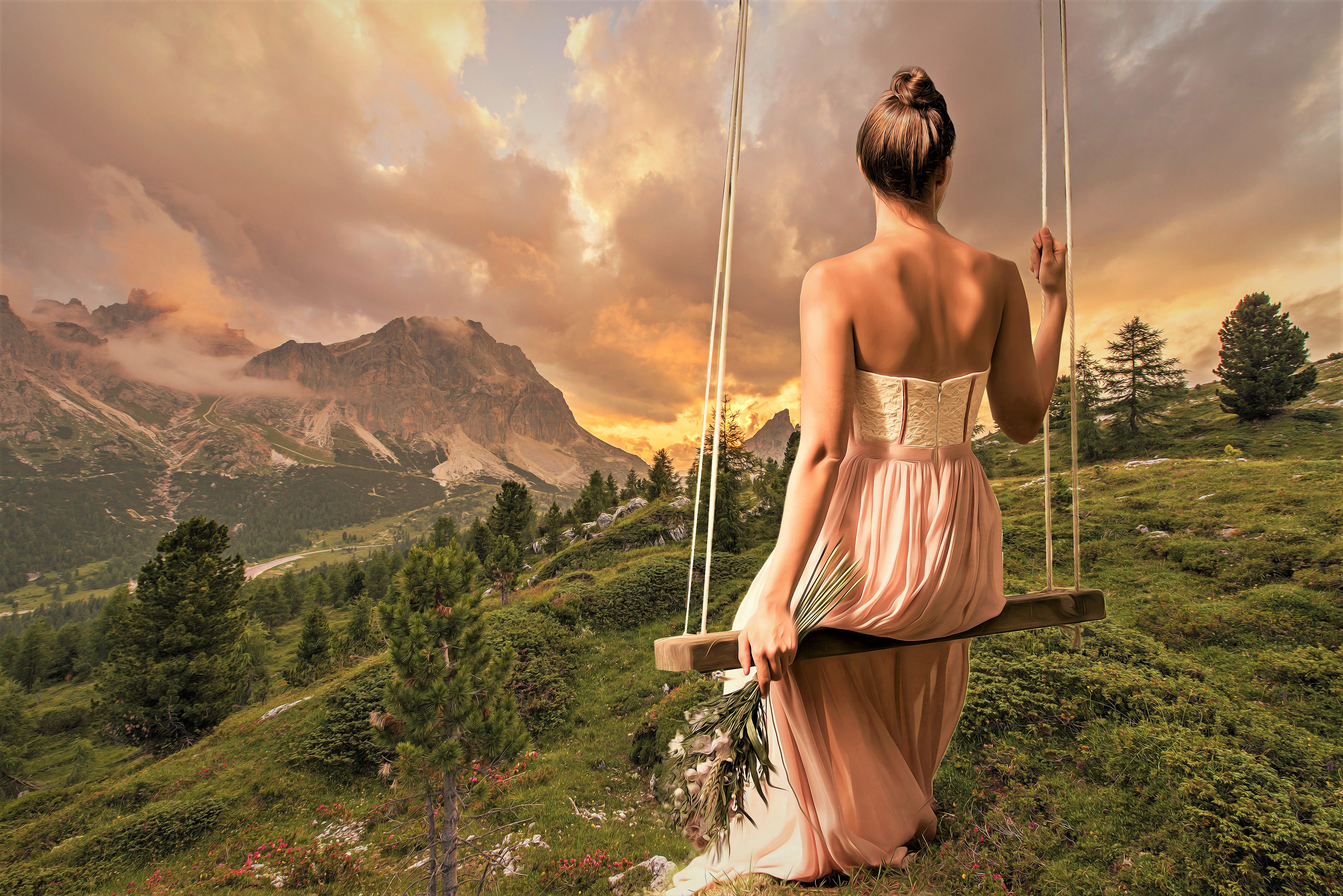 Woman on a swing in the mountains at sunset HD Wallpaper