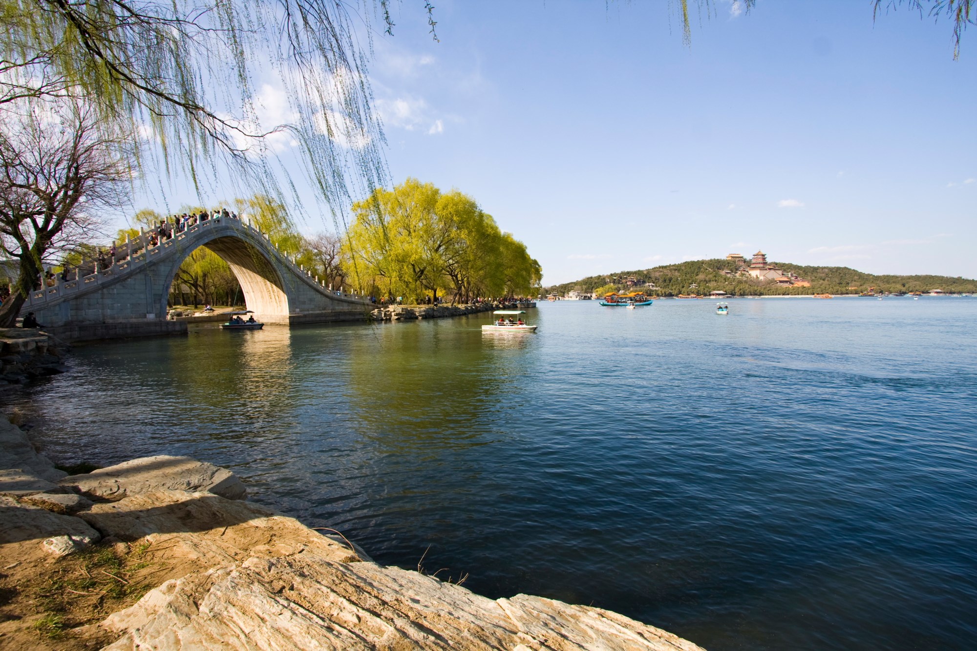 Stone bridge over water with boats and island pagoda HD Wallpaper