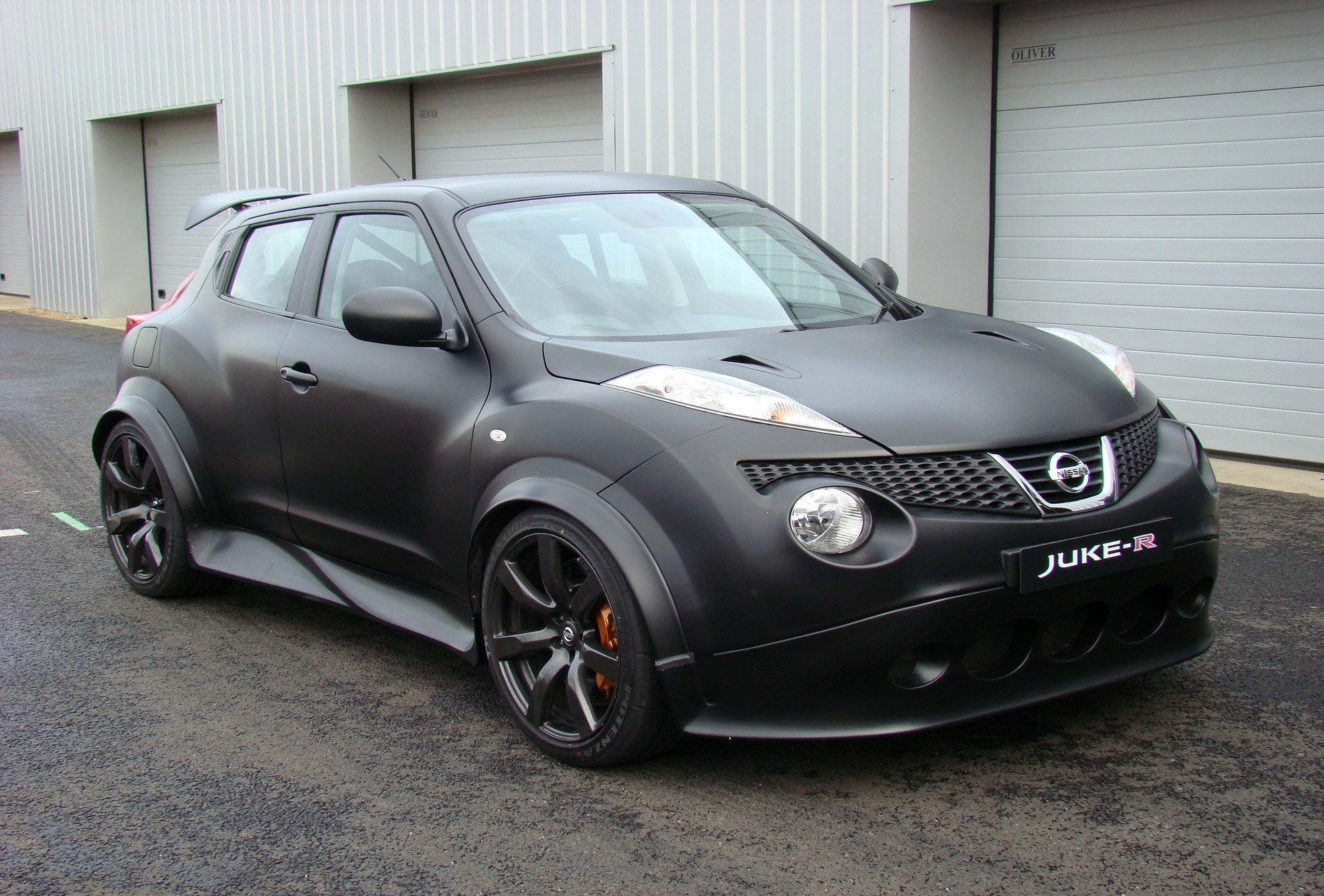 Matte black Nissan Juke-R with spoiler HD Wallpaper