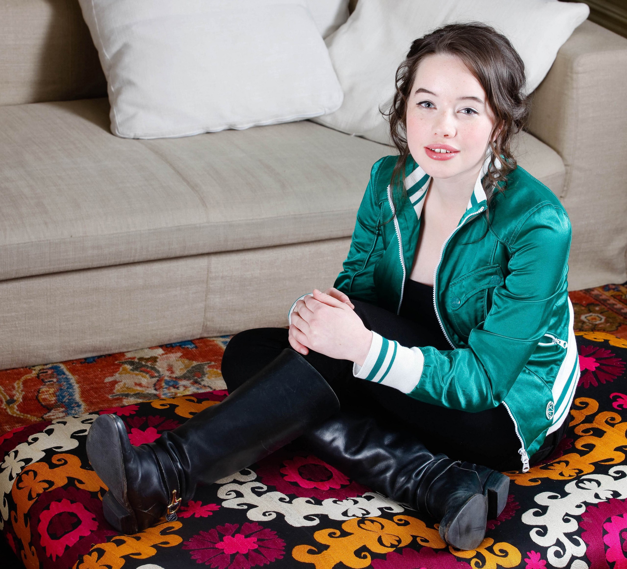 Anna Popplewell sitting on a patterned ottoman HD Wallpaper