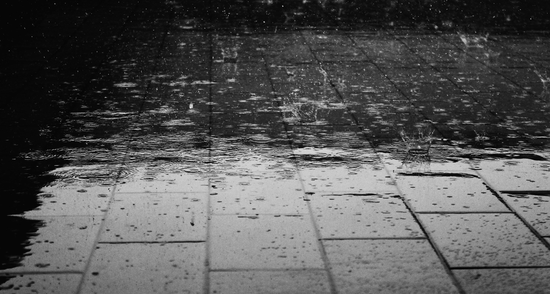 Rain falling on paved ground HD Wallpaper