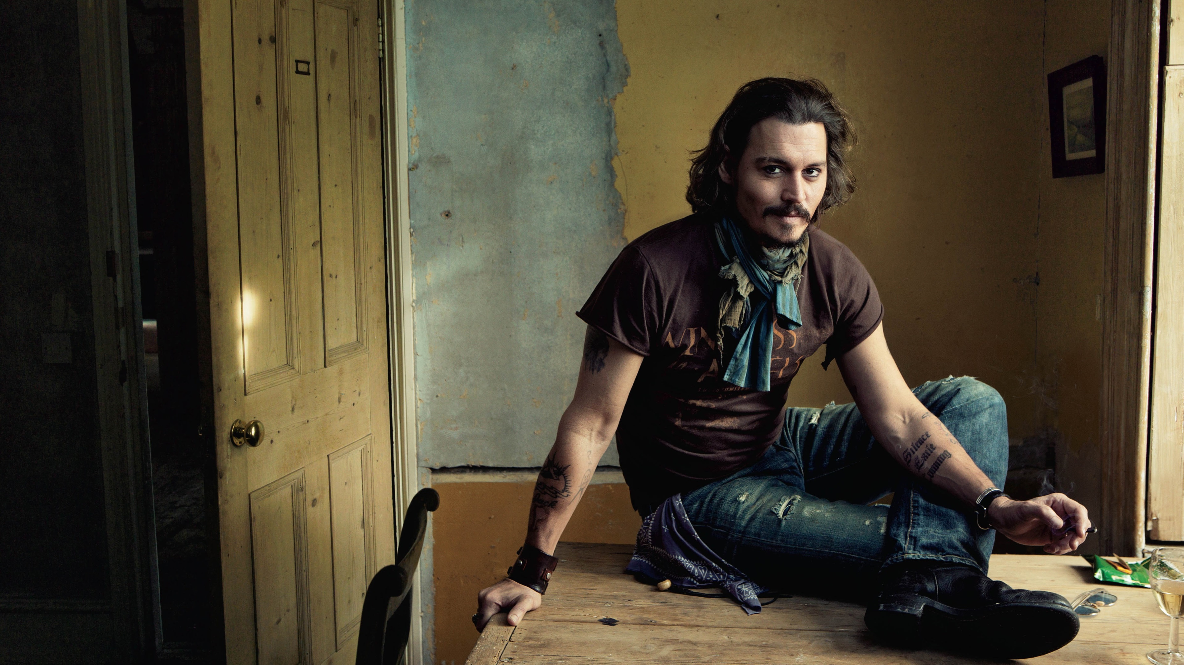 Johnny Depp sitting on a table HD Wallpaper