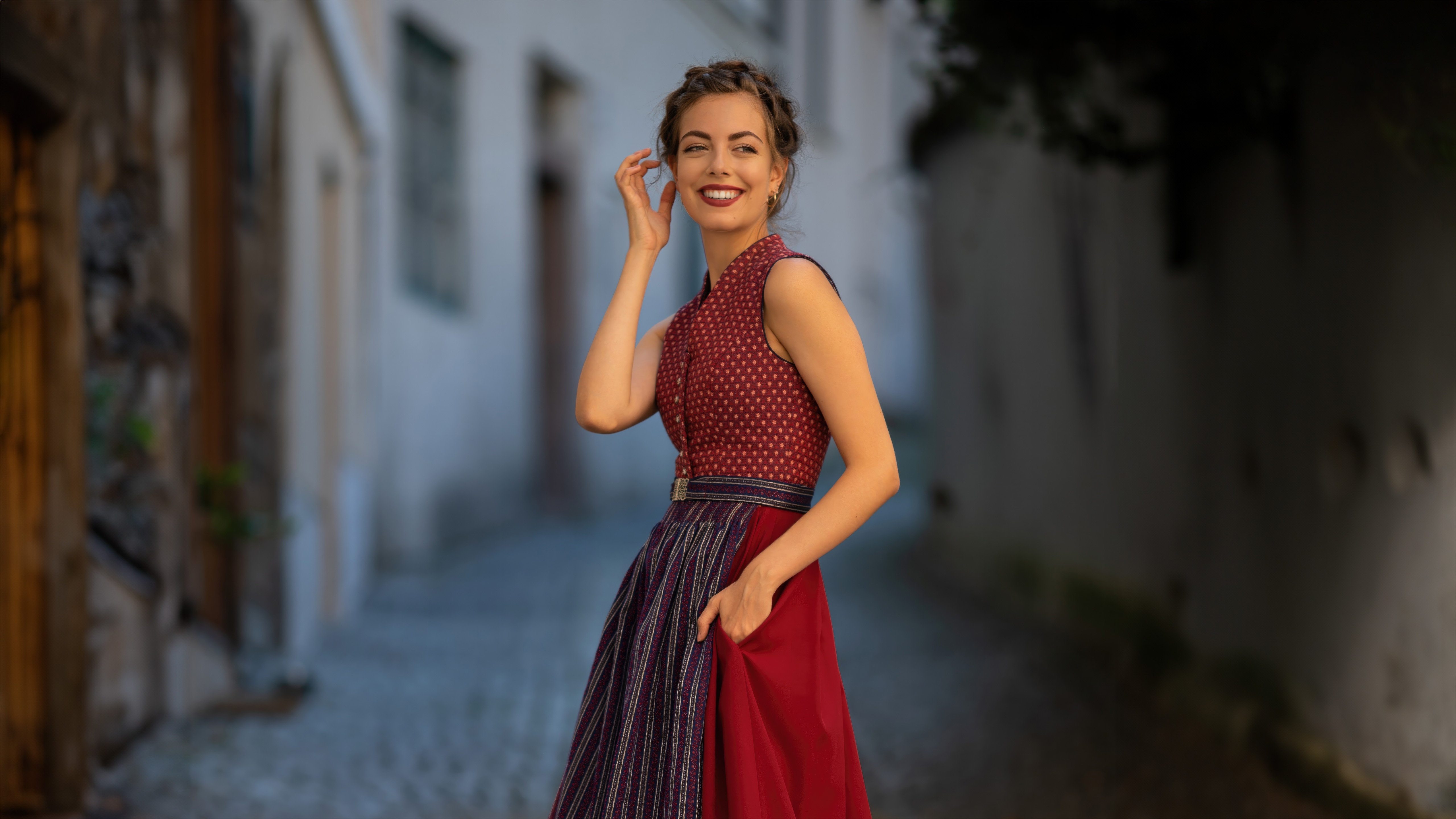 Woman in traditional Bavarian dress smiles HD Wallpaper