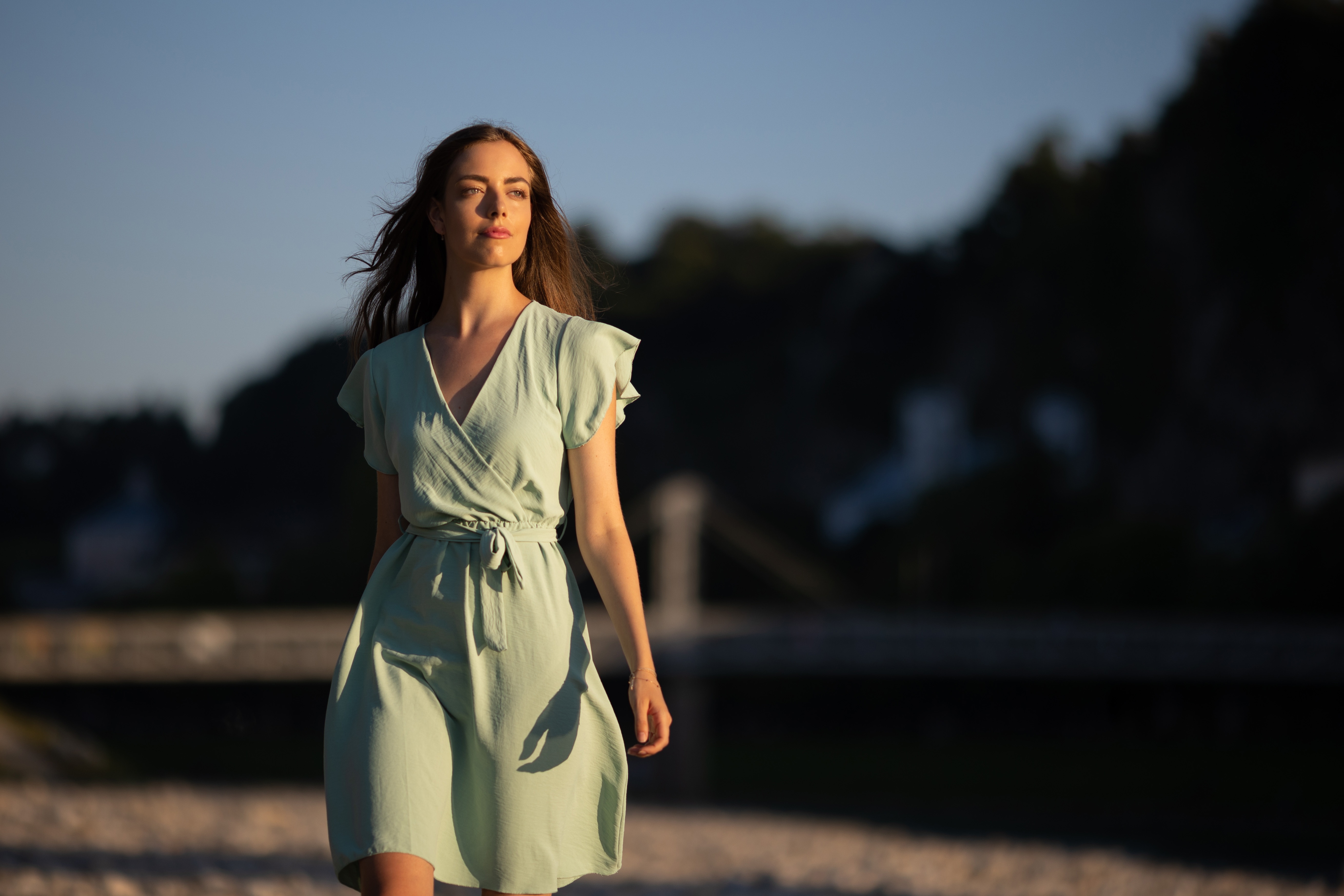 Woman in a light green dress walking by a river HD Wallpaper