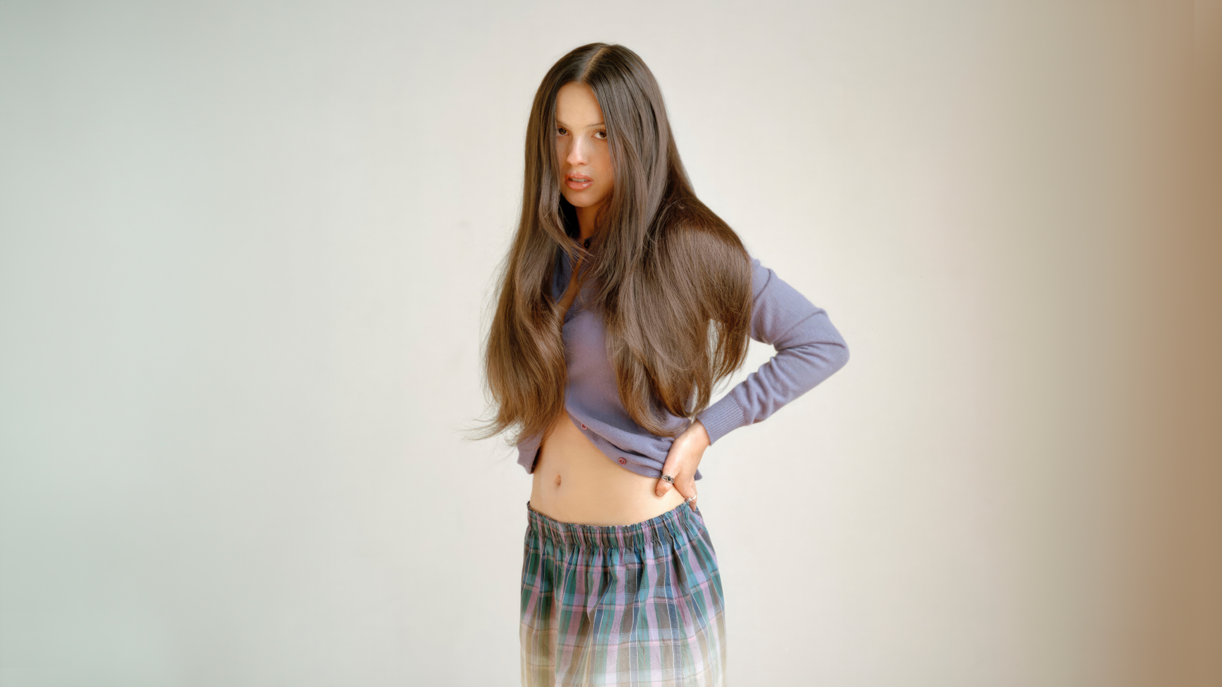 Olivia Rodrigo in a purple sweater and plaid skirt HD Wallpaper