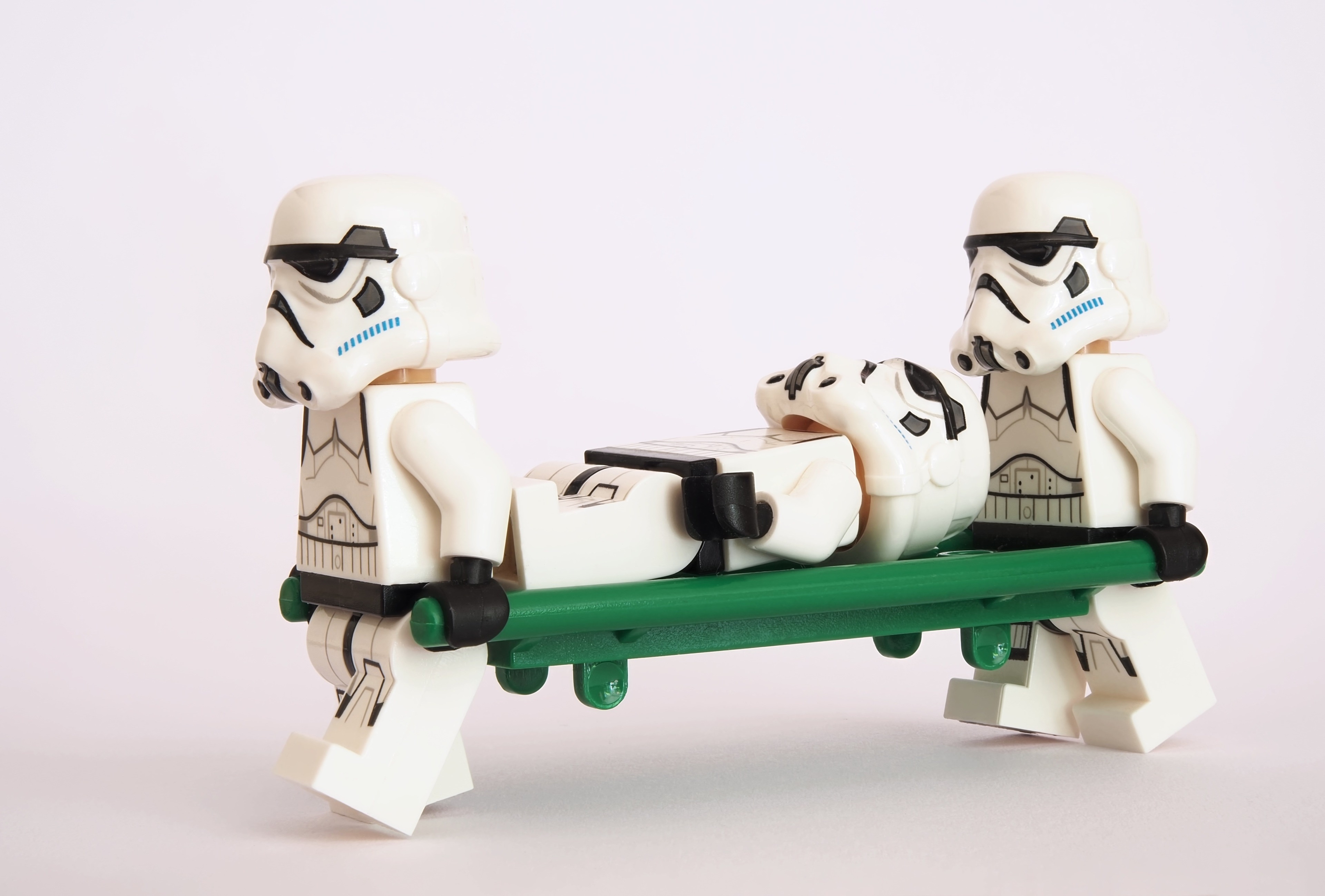 Lego Stormtroopers carrying an injured Stormtrooper on a stretcher HD Wallpaper