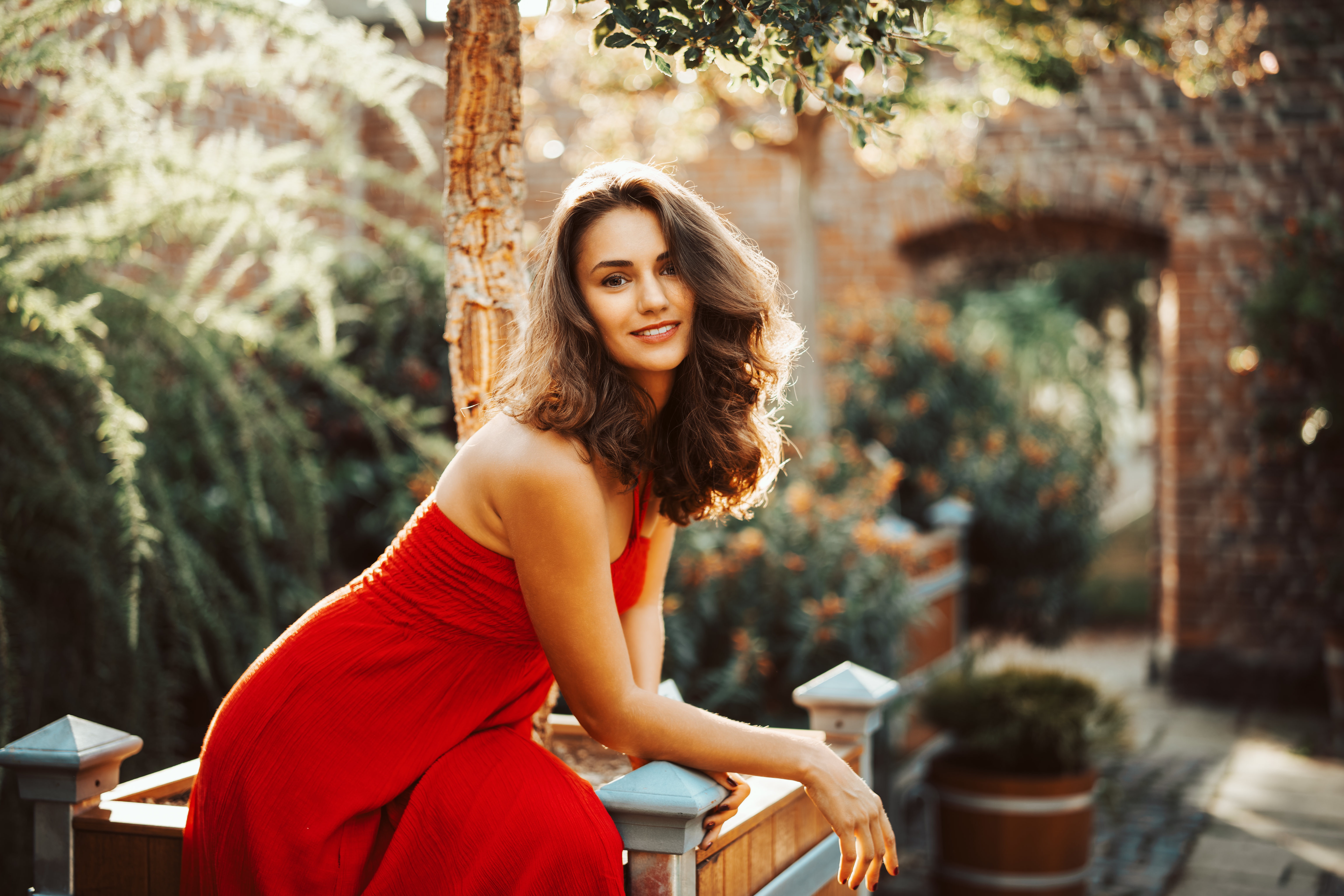 Woman in red dress in a garden HD Wallpaper