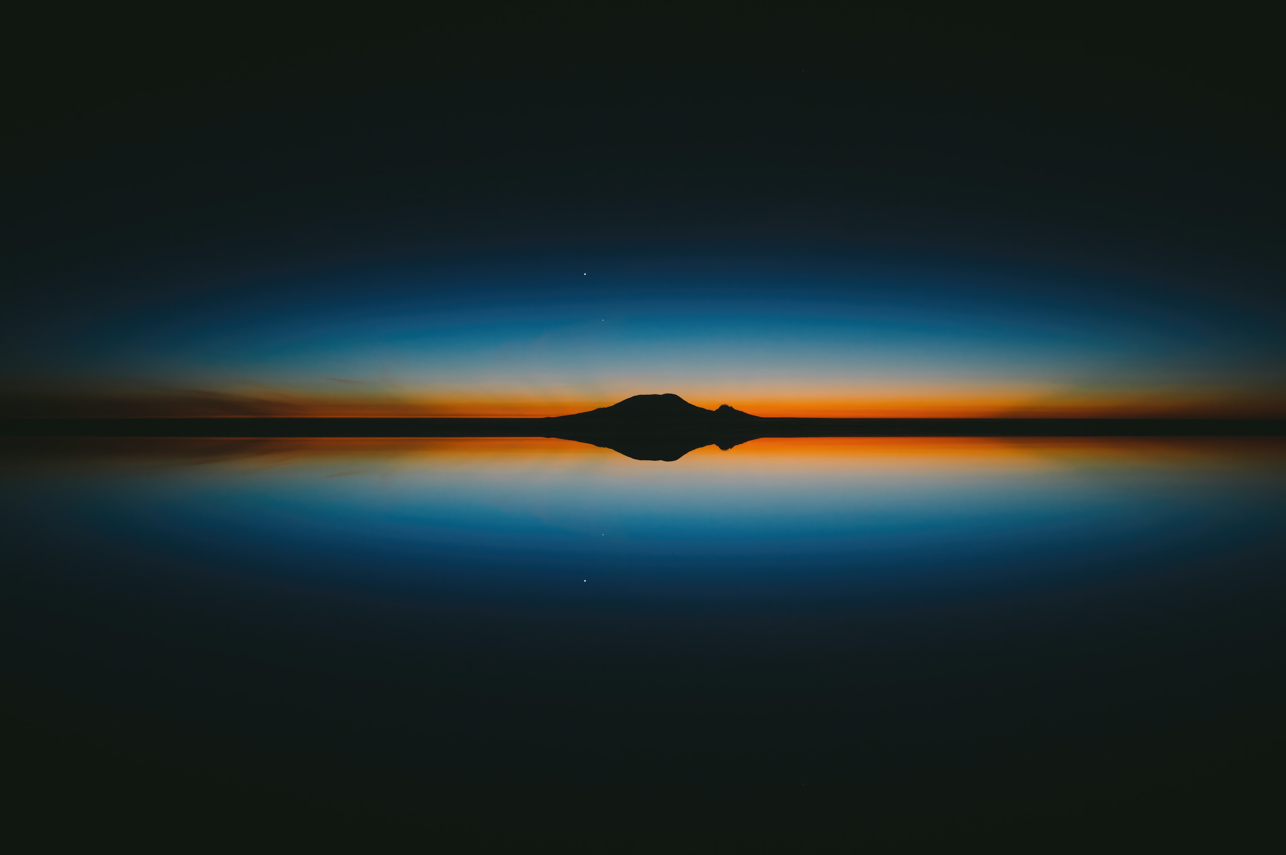 Minimalist sunset over a calm body of water with island silhouette HD Wallpaper