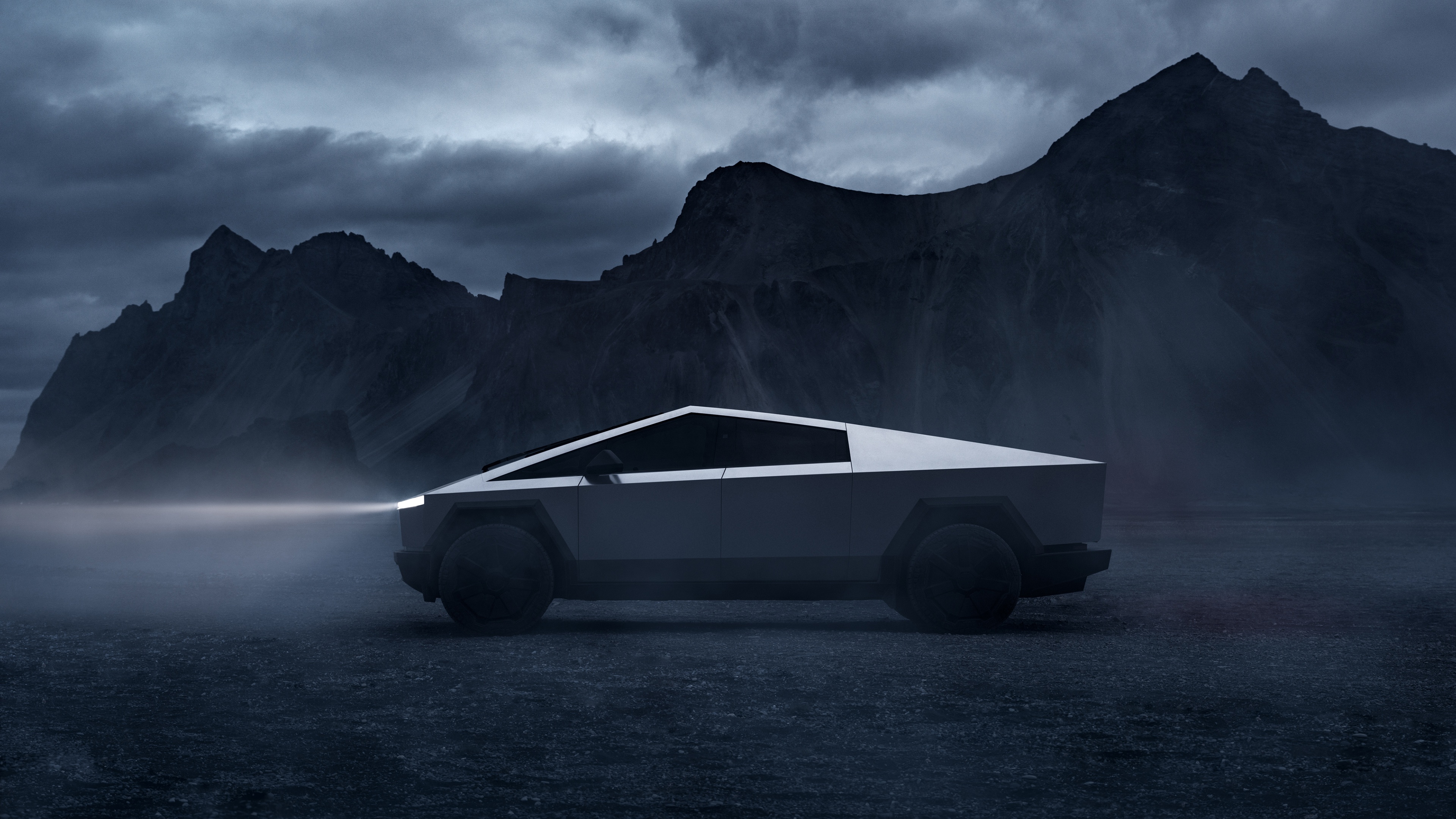 Tesla Cybertruck driving at night in a mountainous landscape HD Wallpaper