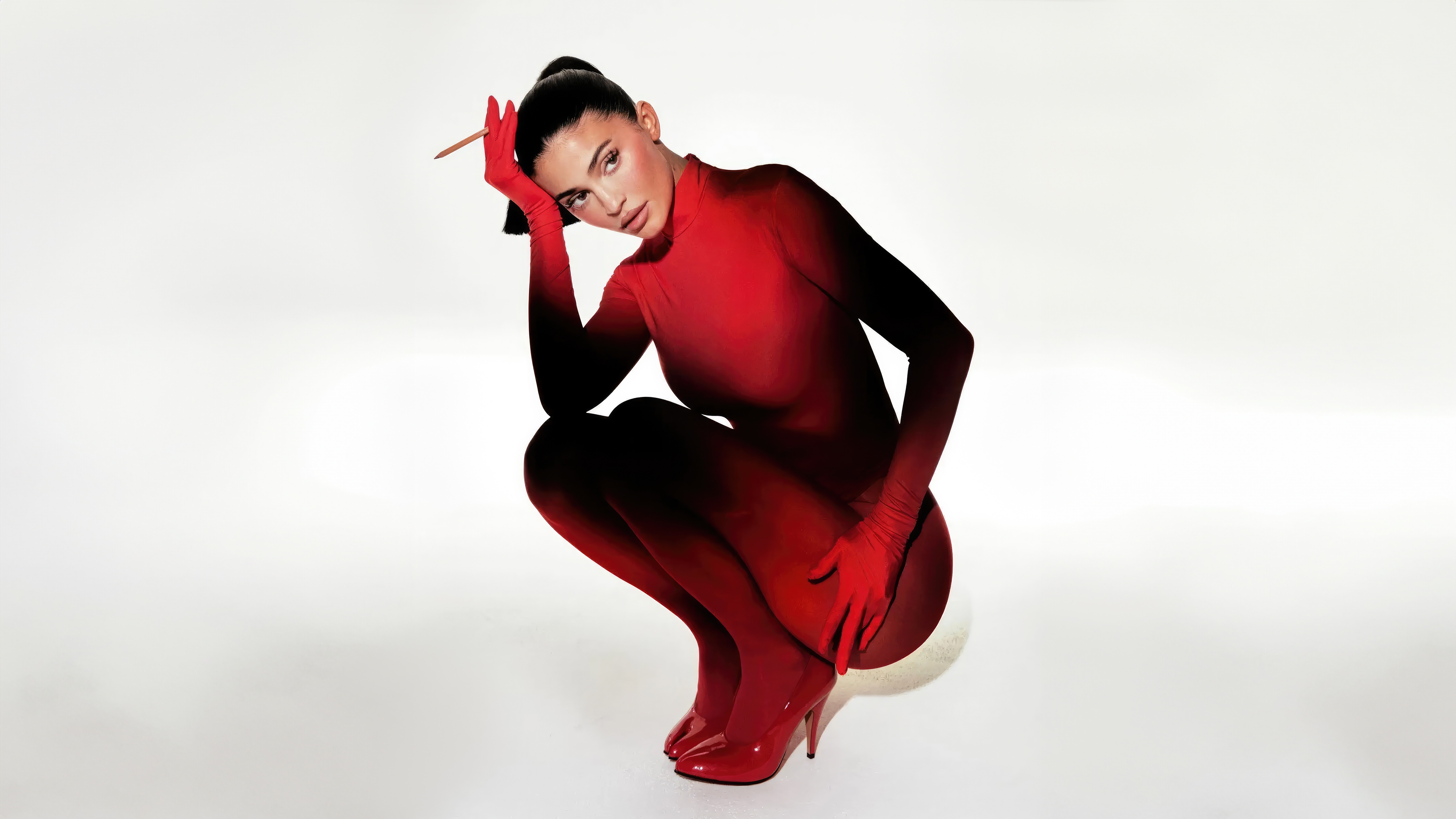 Kylie Jenner in a red bodysuit and heels HD Wallpaper