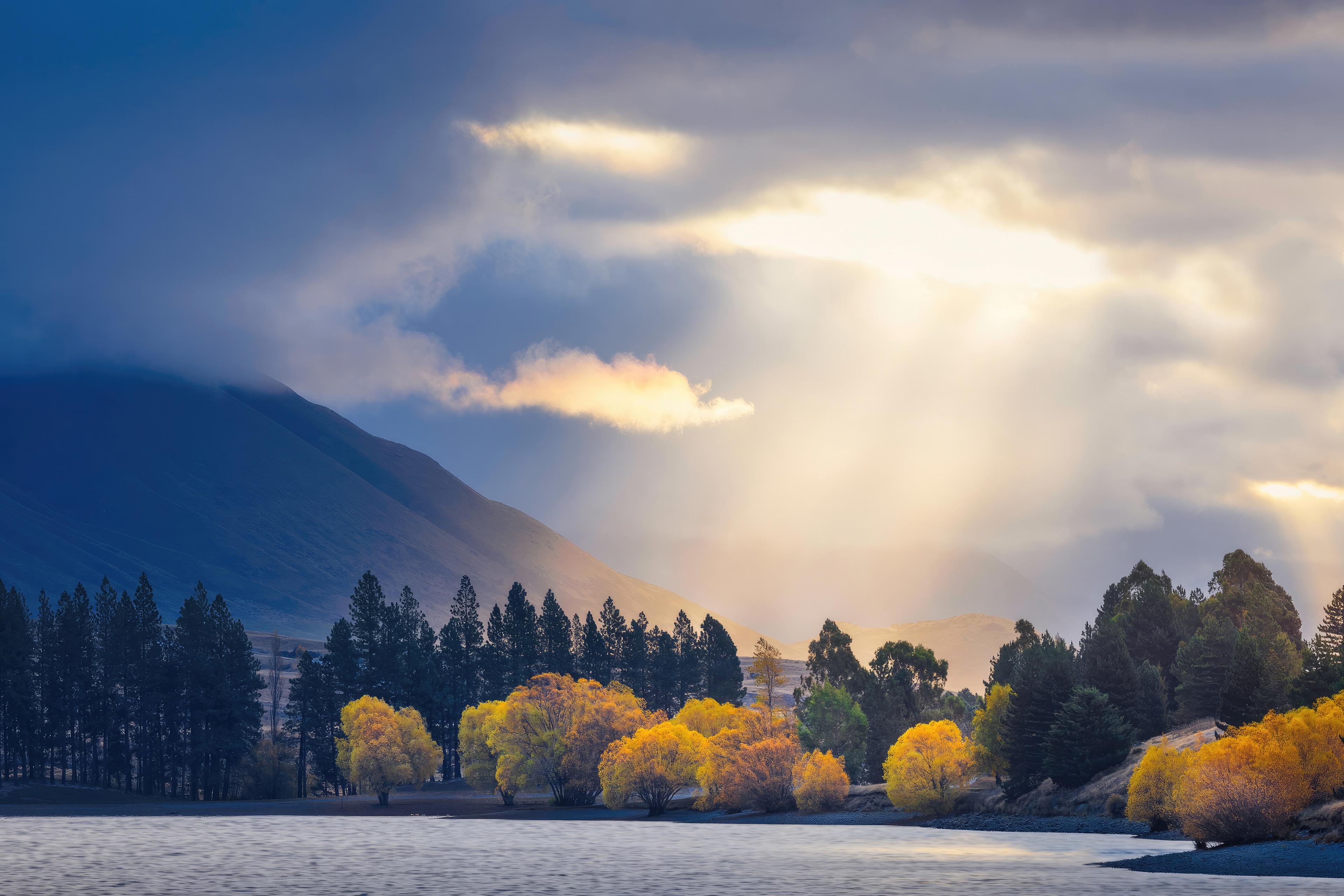 Sunbeams over a lake with autumn trees and mountains HD Wallpaper
