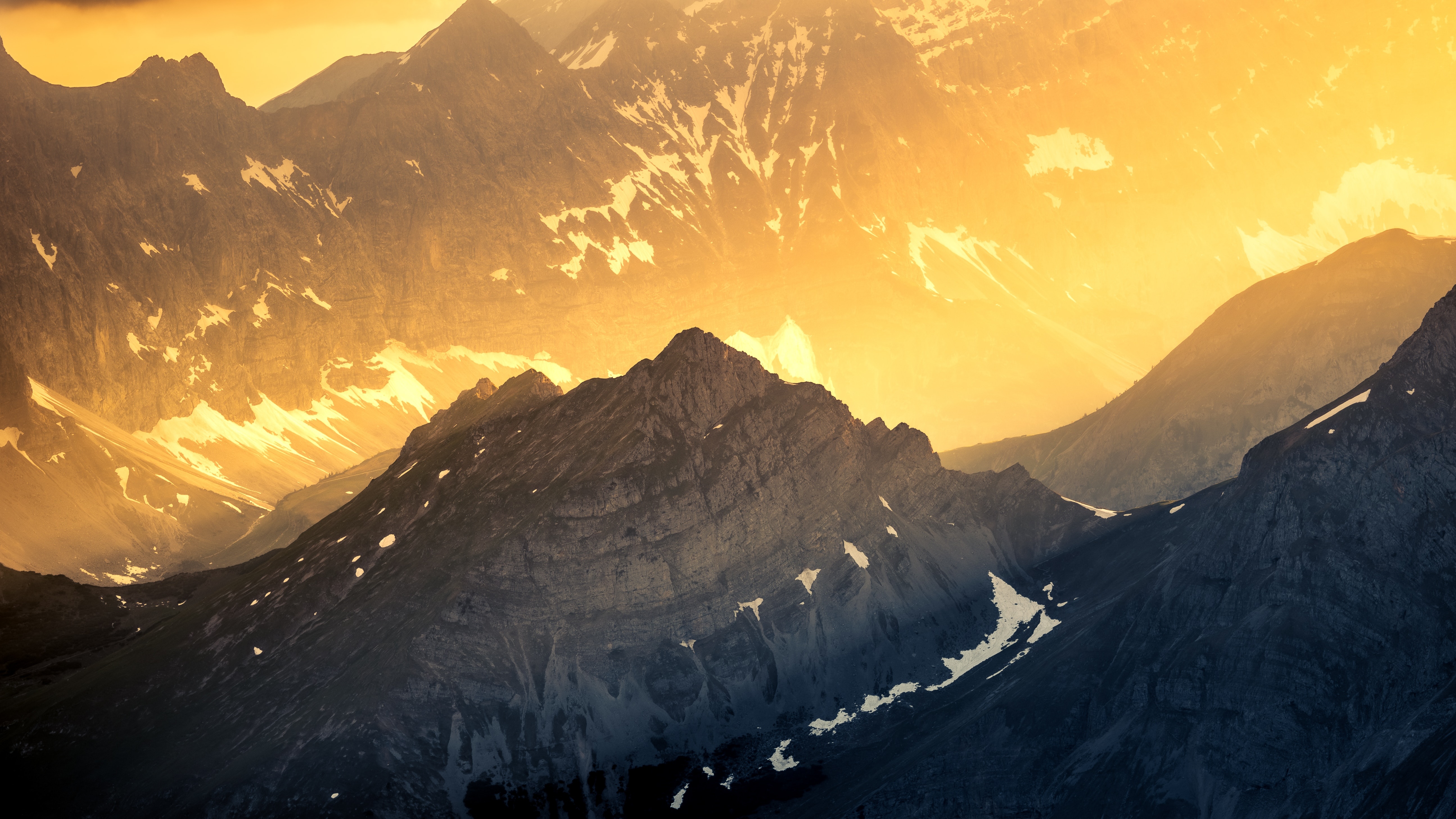 Golden light illuminates majestic mountain peaks in autumn HD Wallpaper