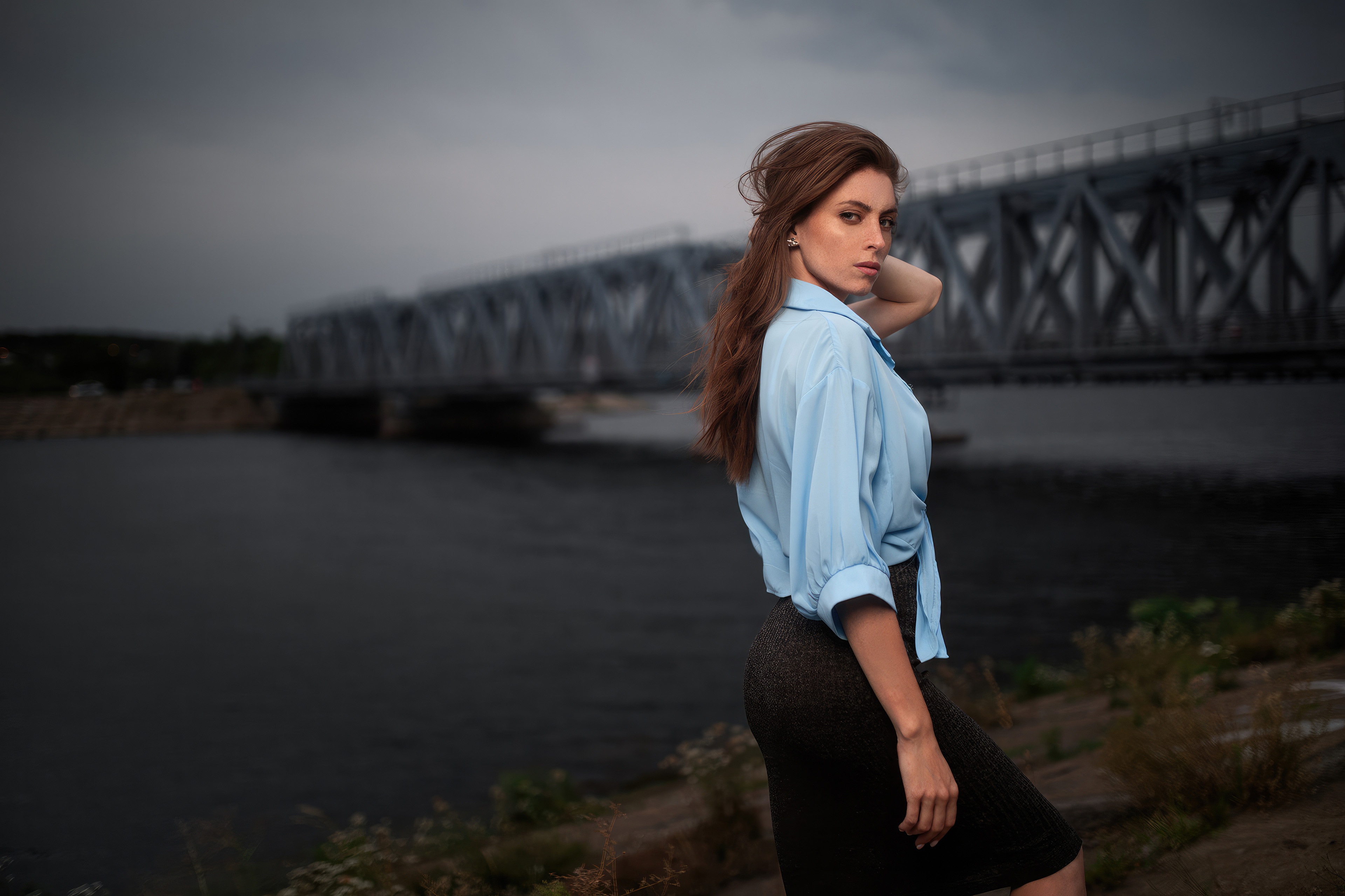 Woman in blue shirt and skirt by a bridge HD Wallpaper