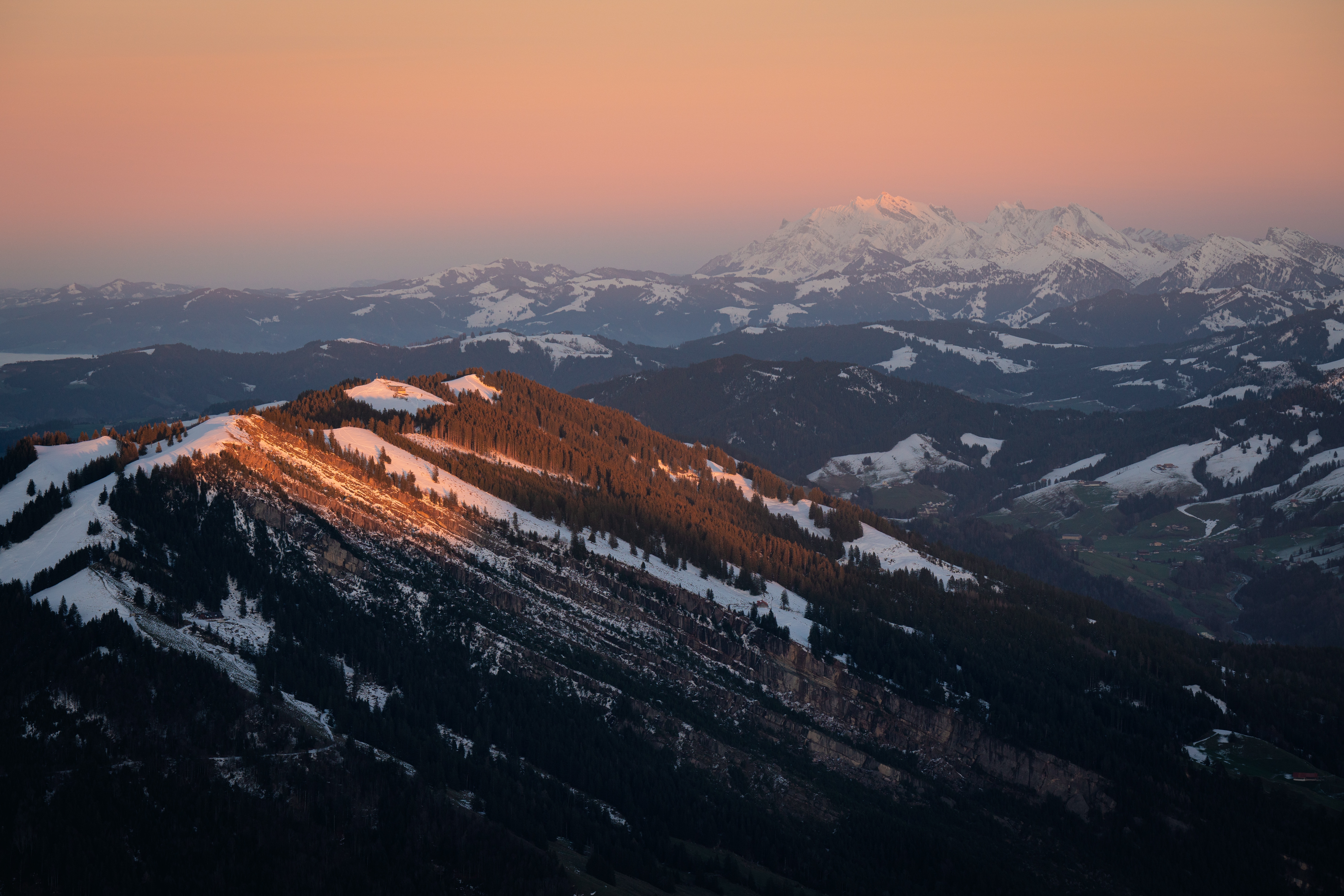 Snow-capped mountains bathed in sunrise glow HD Wallpaper