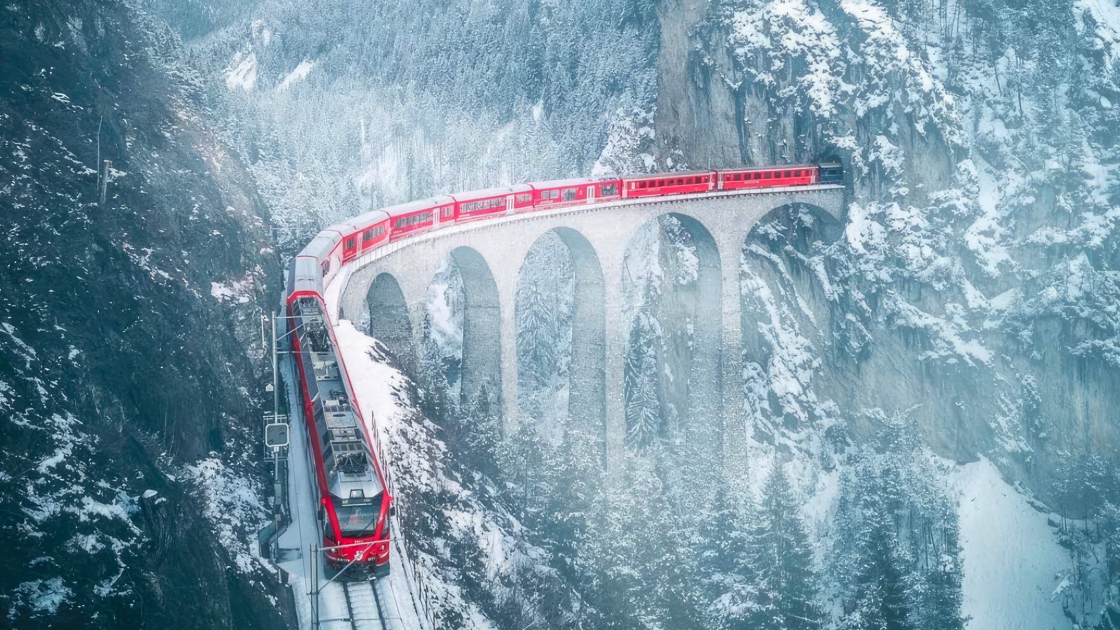 Red train on a snowy viaduct in Switzerland HD Wallpaper