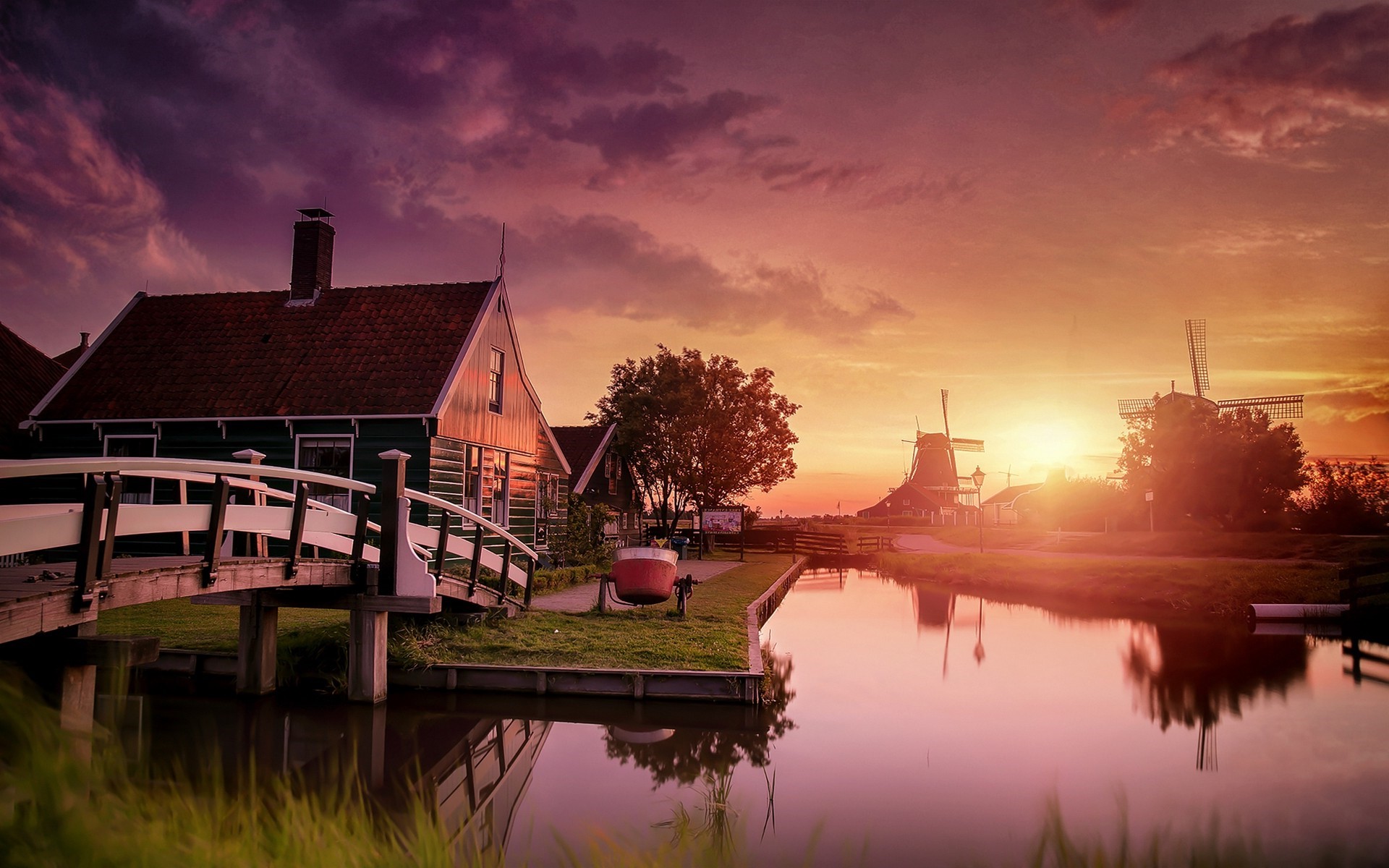 Sunset over canal with windmills and houses in Zaanse Schans, Netherlands HD Wallpaper