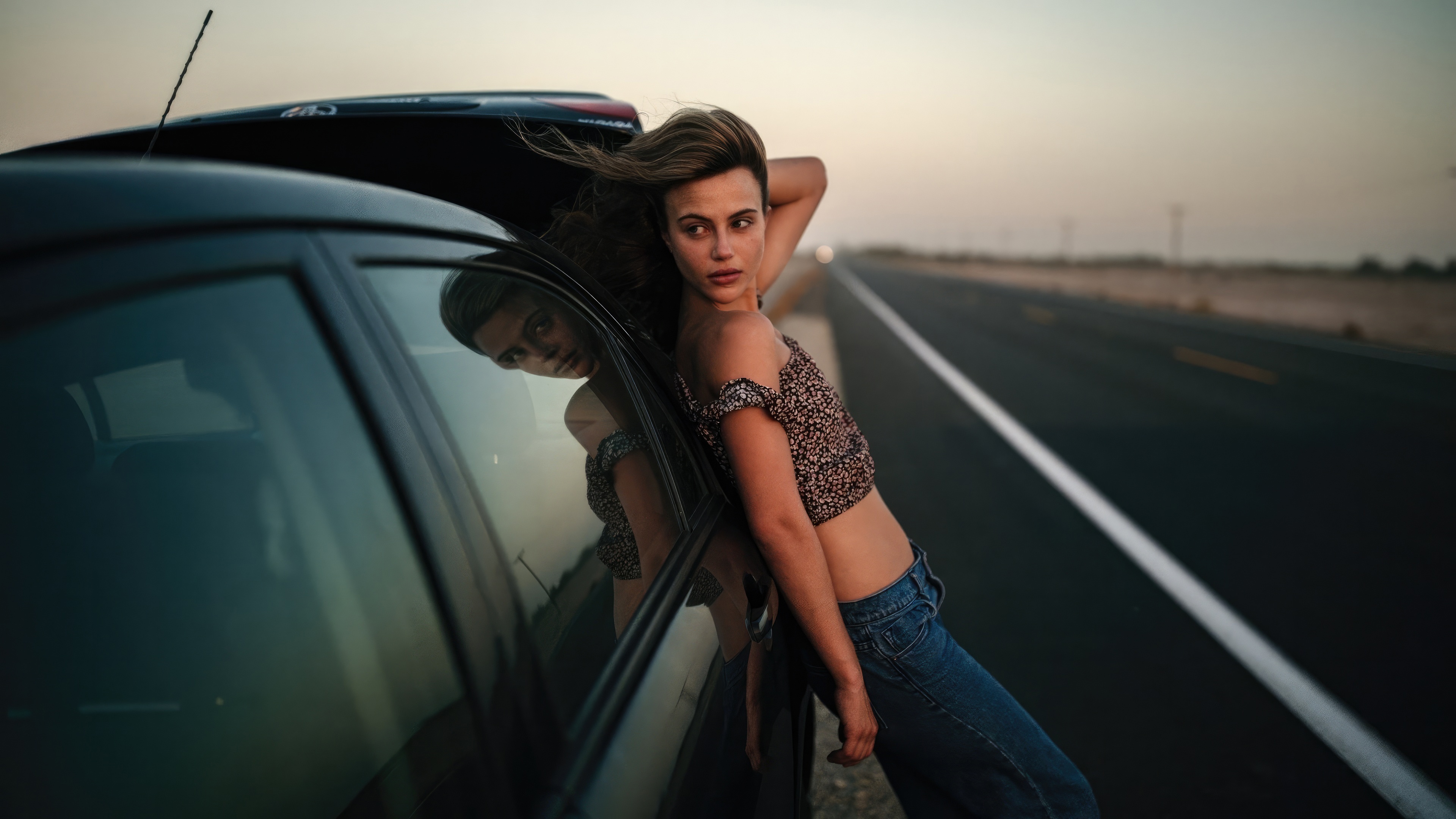 Woman leaning on car on a desert highway HD Wallpaper