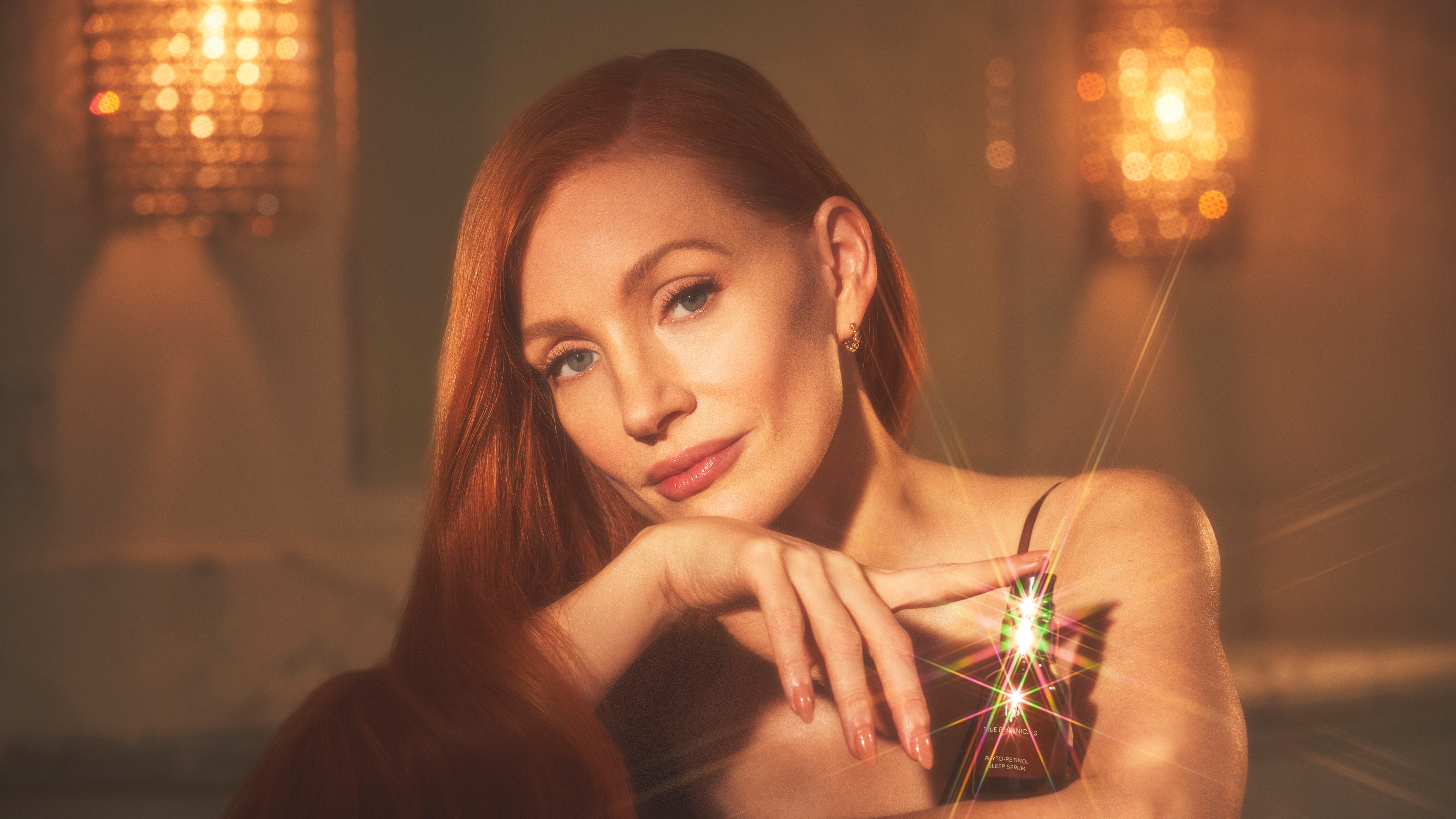 Jessica Chastain poses with a perfume bottle HD Wallpaper